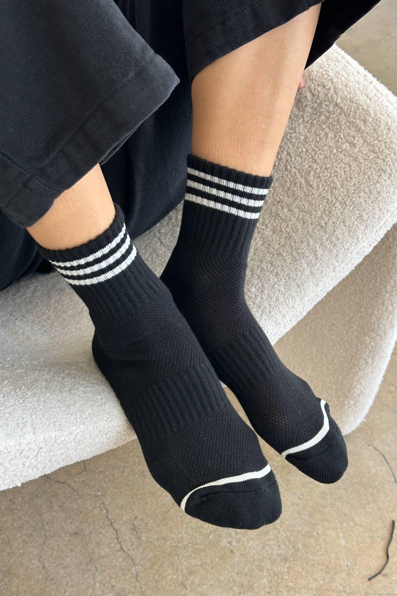 Le Bon Shoppe black cotton blend socks with white stripes, worn on feet indoors