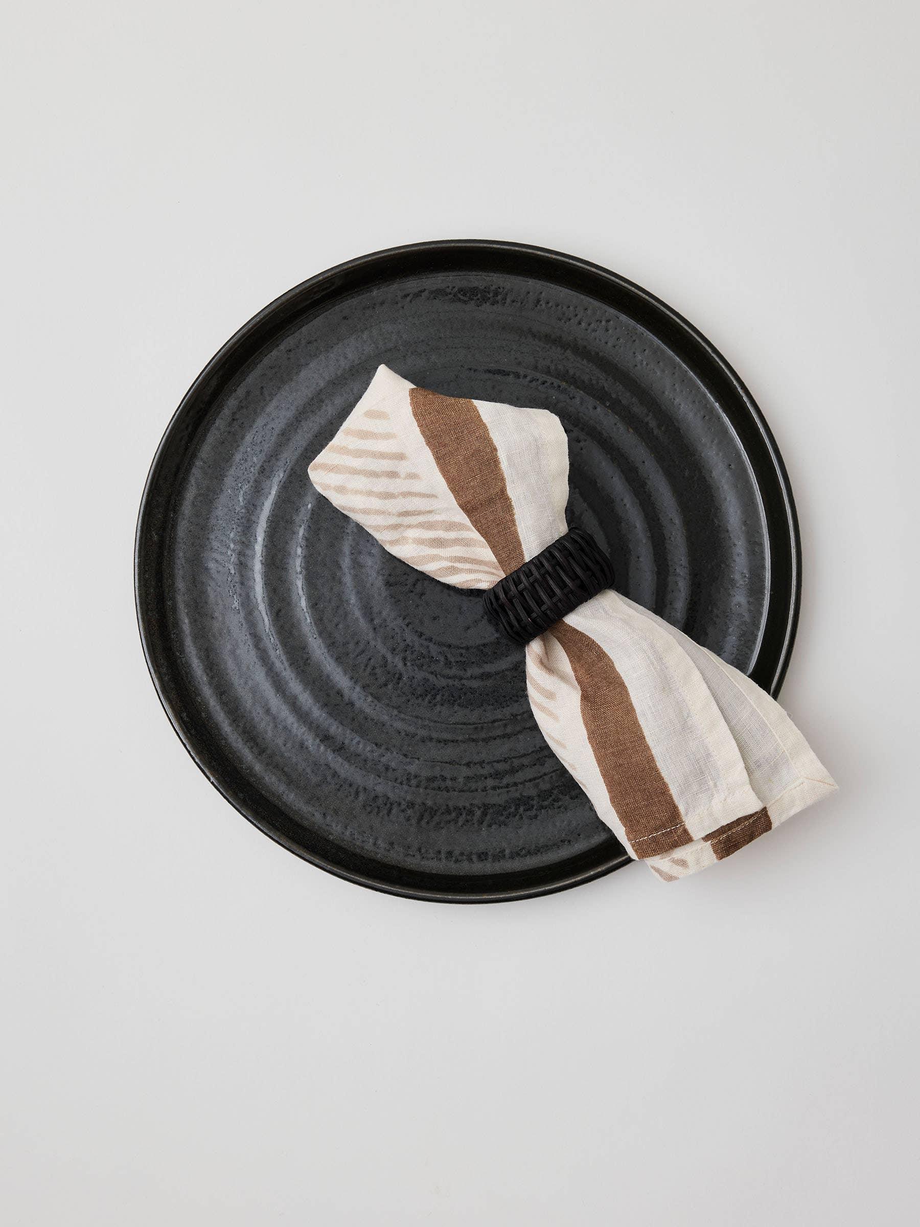 Fazeek ceramic plate with linen napkin and black napkin ring, earth tones