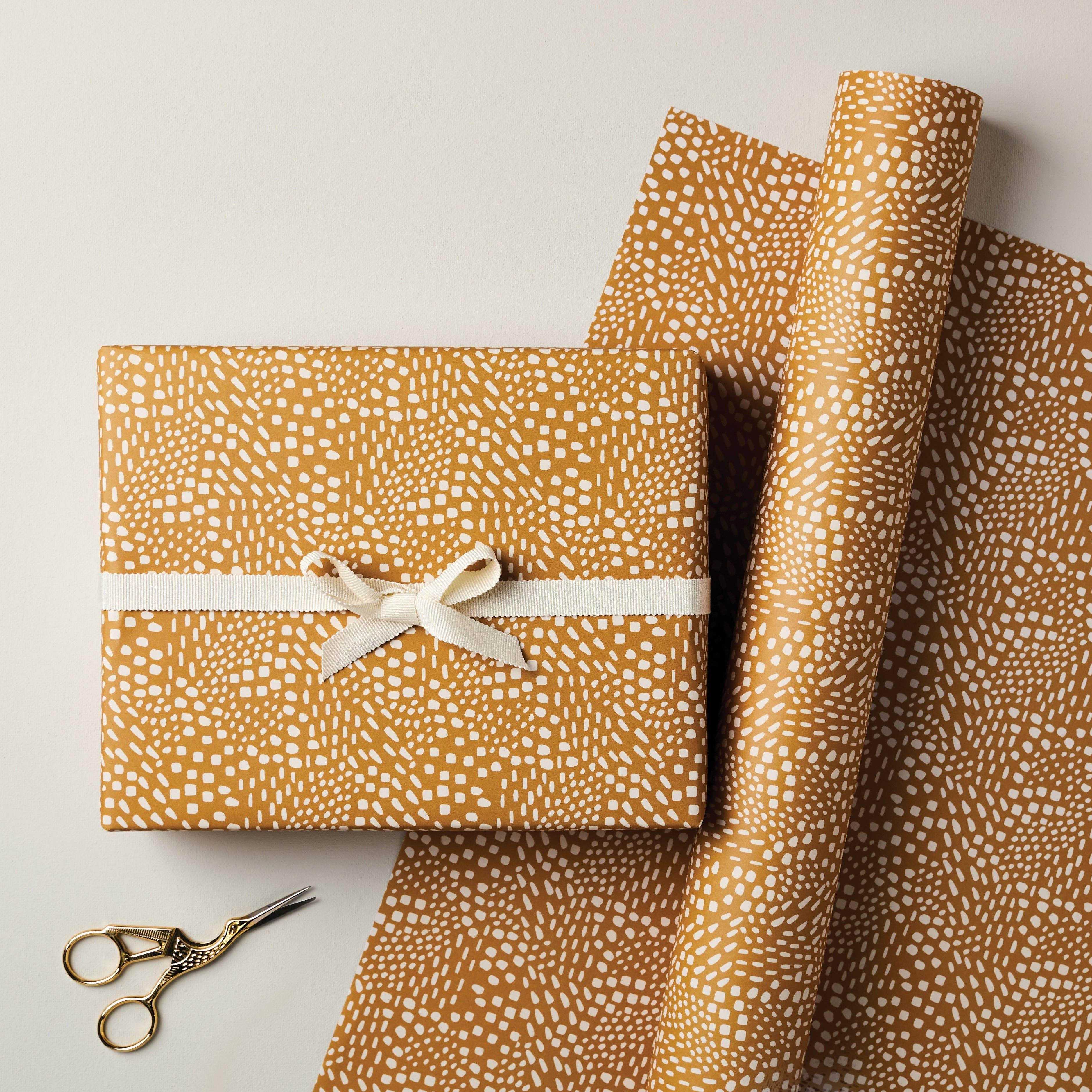 Moglea premium gift wrap paper in ochre and white geometric pattern with ribbon and gold scissors