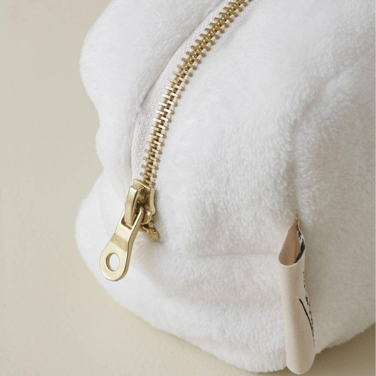 LeSportsac pouch in white plush fabric with gold zipper and fabric tag detail