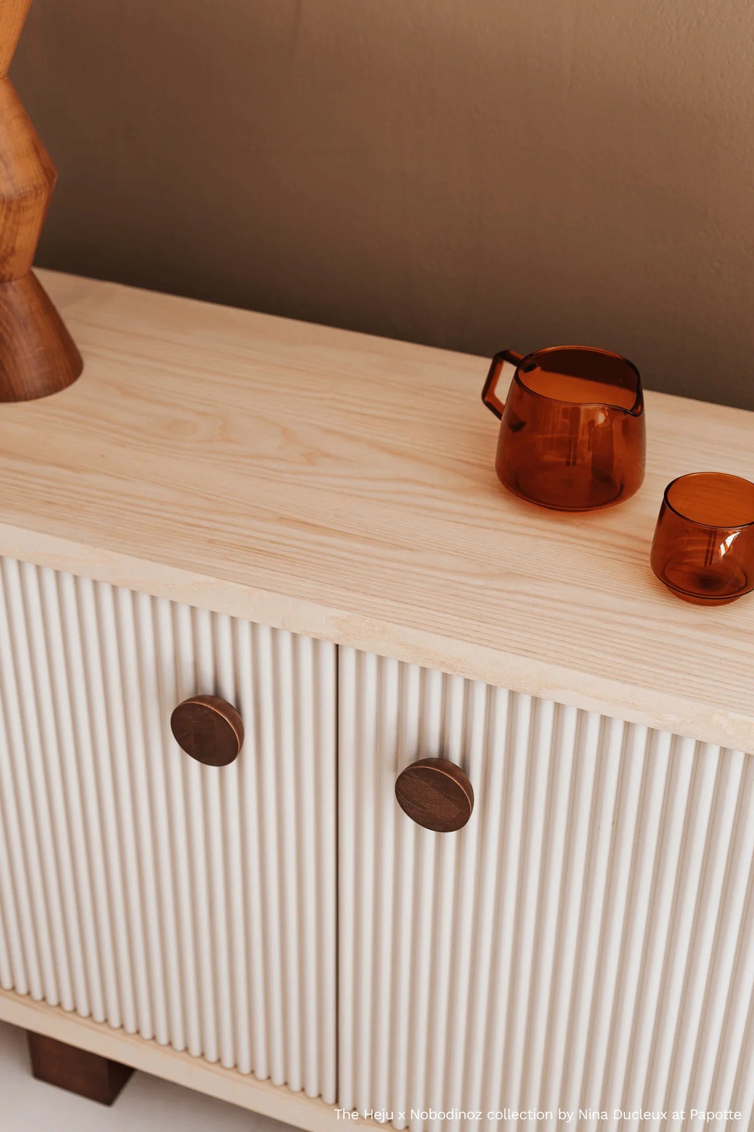 Heju x Nobodinoz sideboard, light wood and cream, fluted doors with brown knobs.