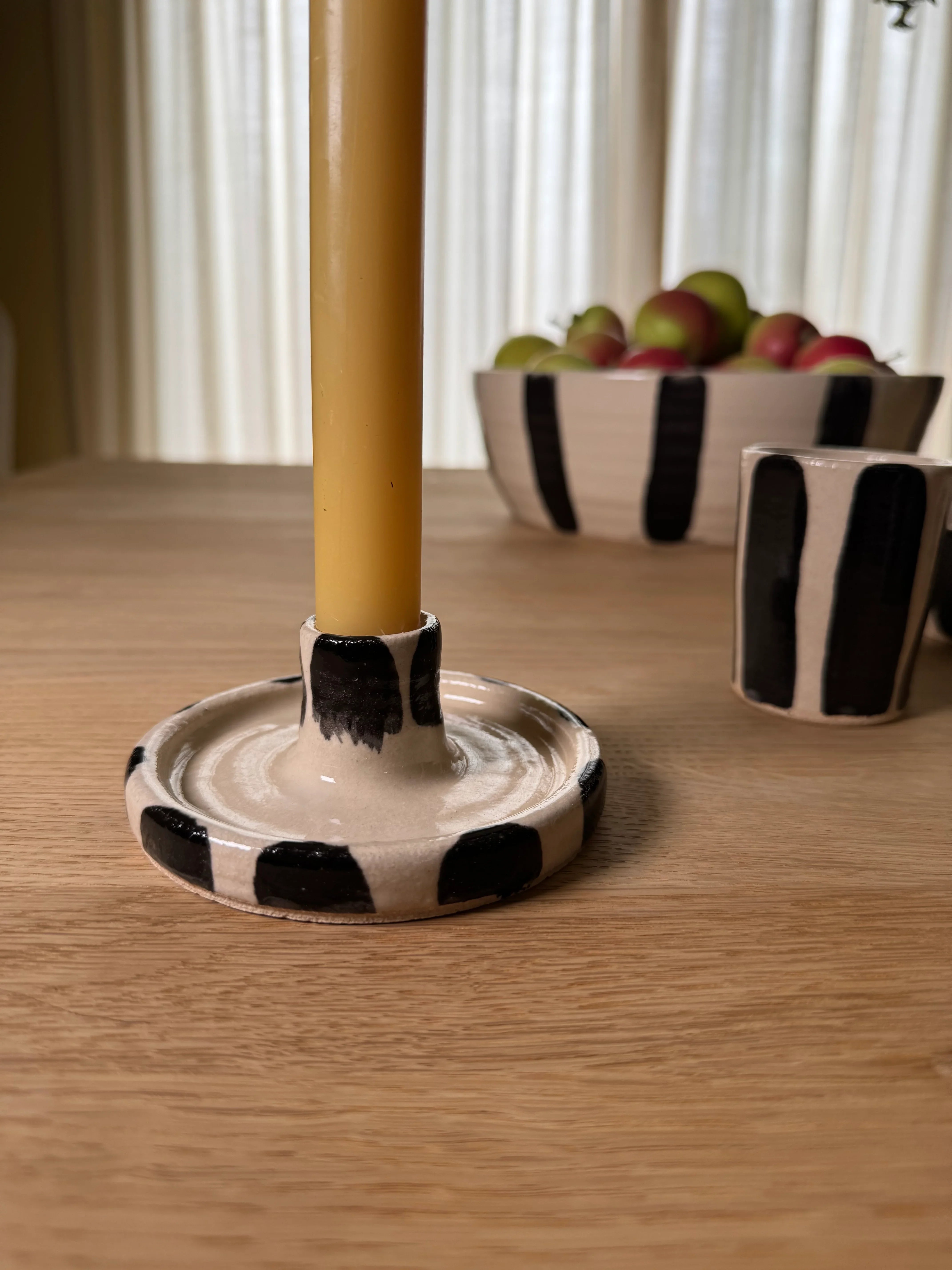 Mimi Ceramics black and white striped ceramic candlestick holder on wooden table