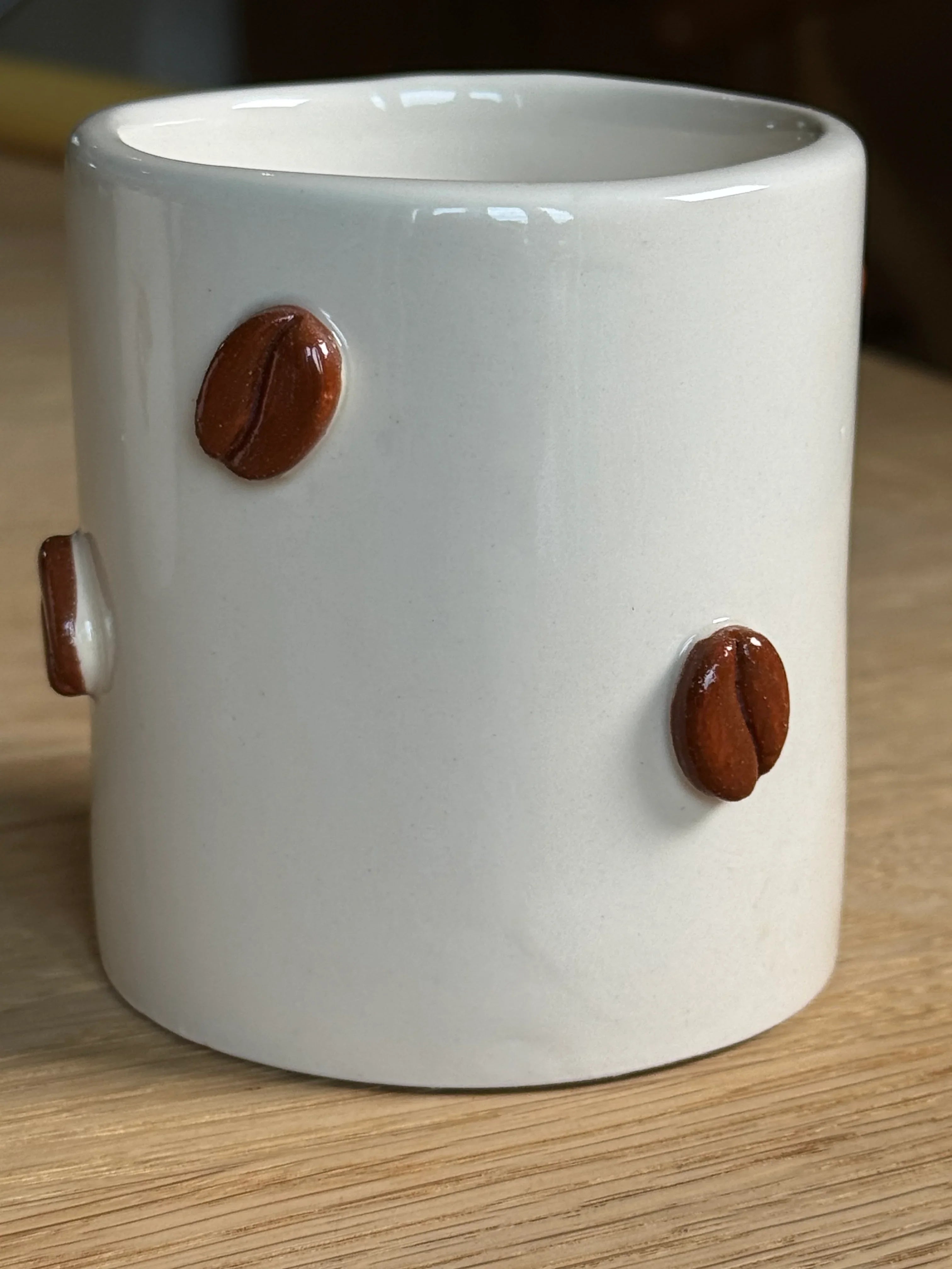 Tierra Rayada ceramic mug with white glaze and raised brown coffee bean decor