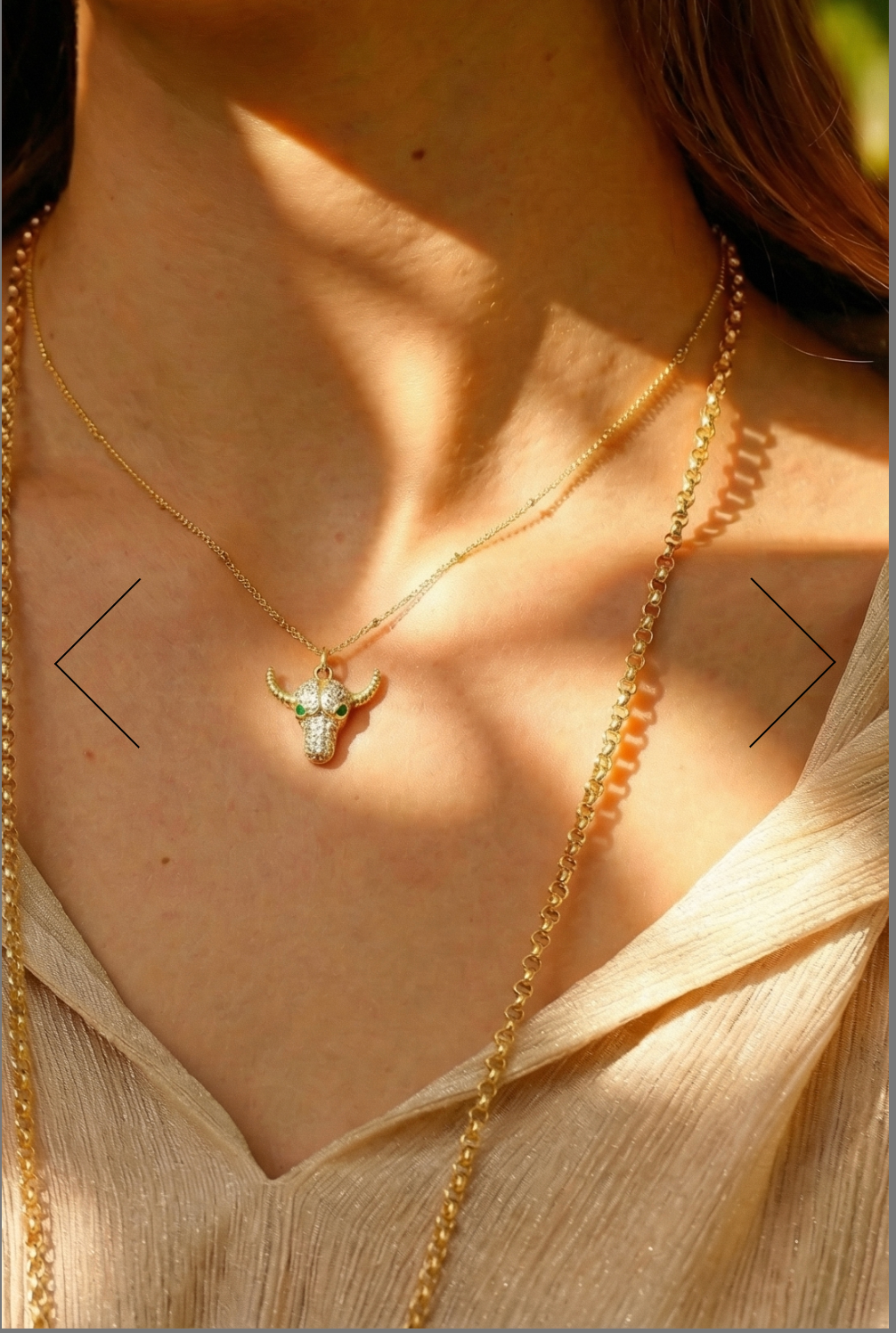 Close-up of a person wearing a gold necklace with a small pendant.
