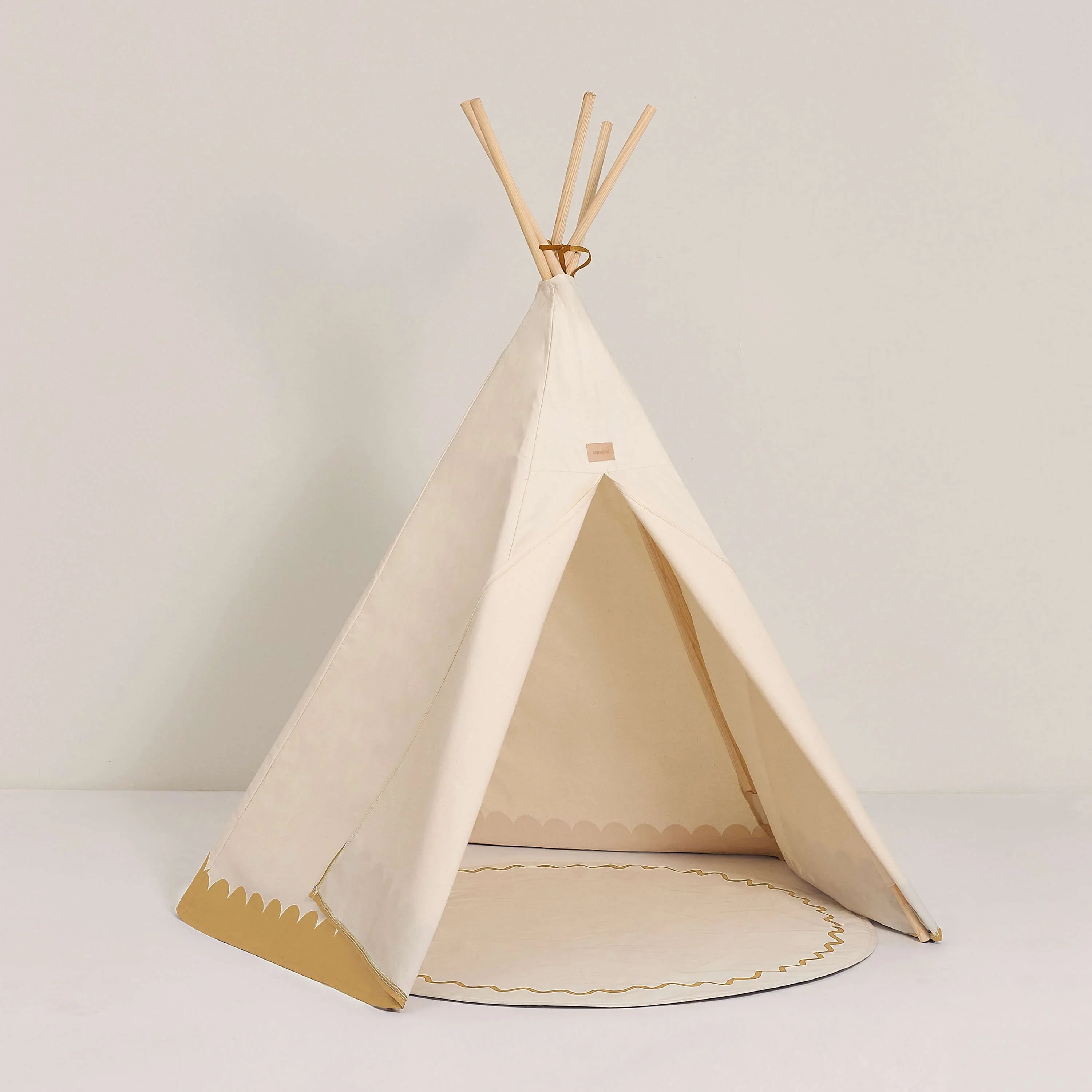 Nobodinoz Arizona ochre cotton teepee tent with wooden poles on a white background
