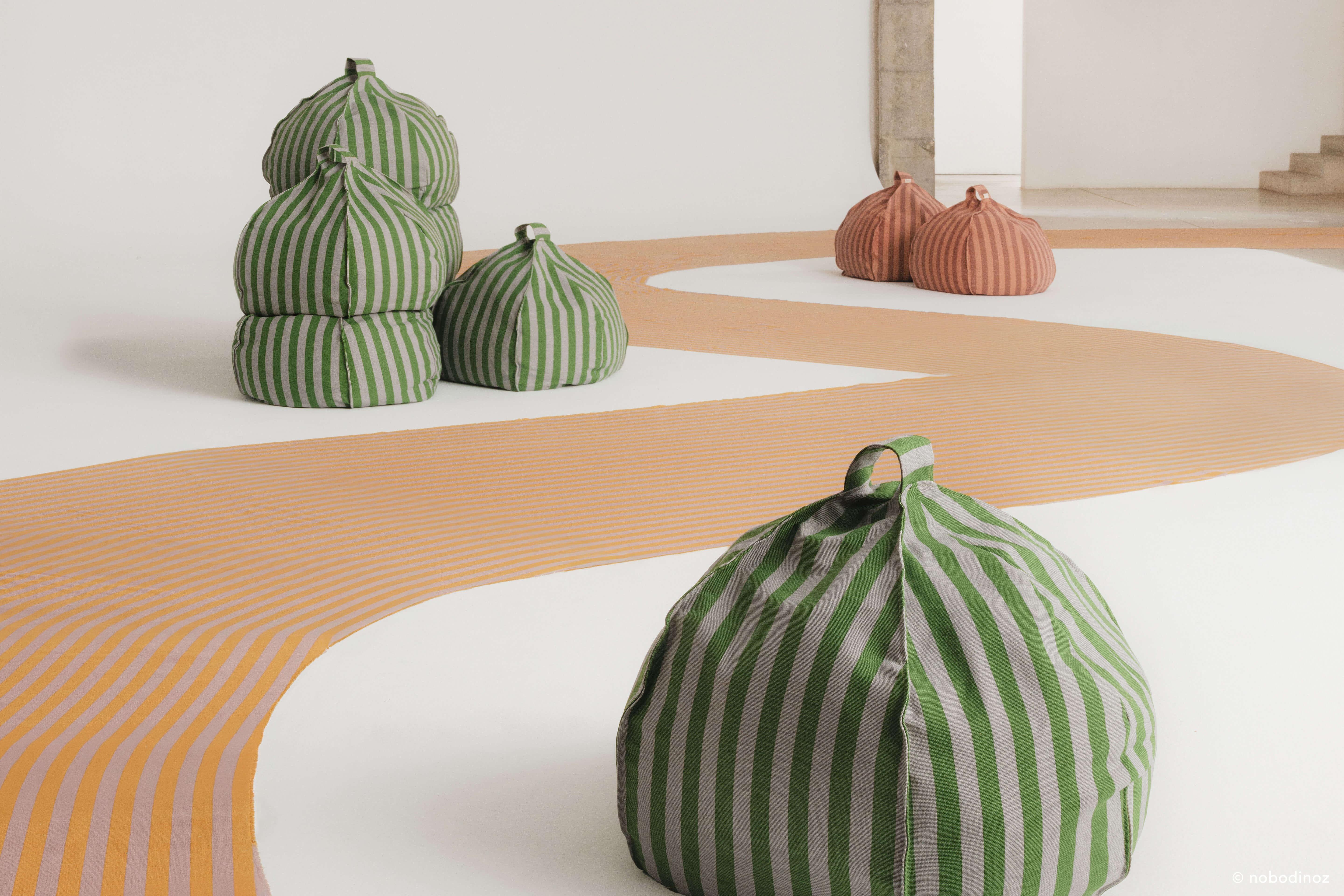 Nobodinoz round bean bag in pink mauve and green striped cotton, modern interior setting