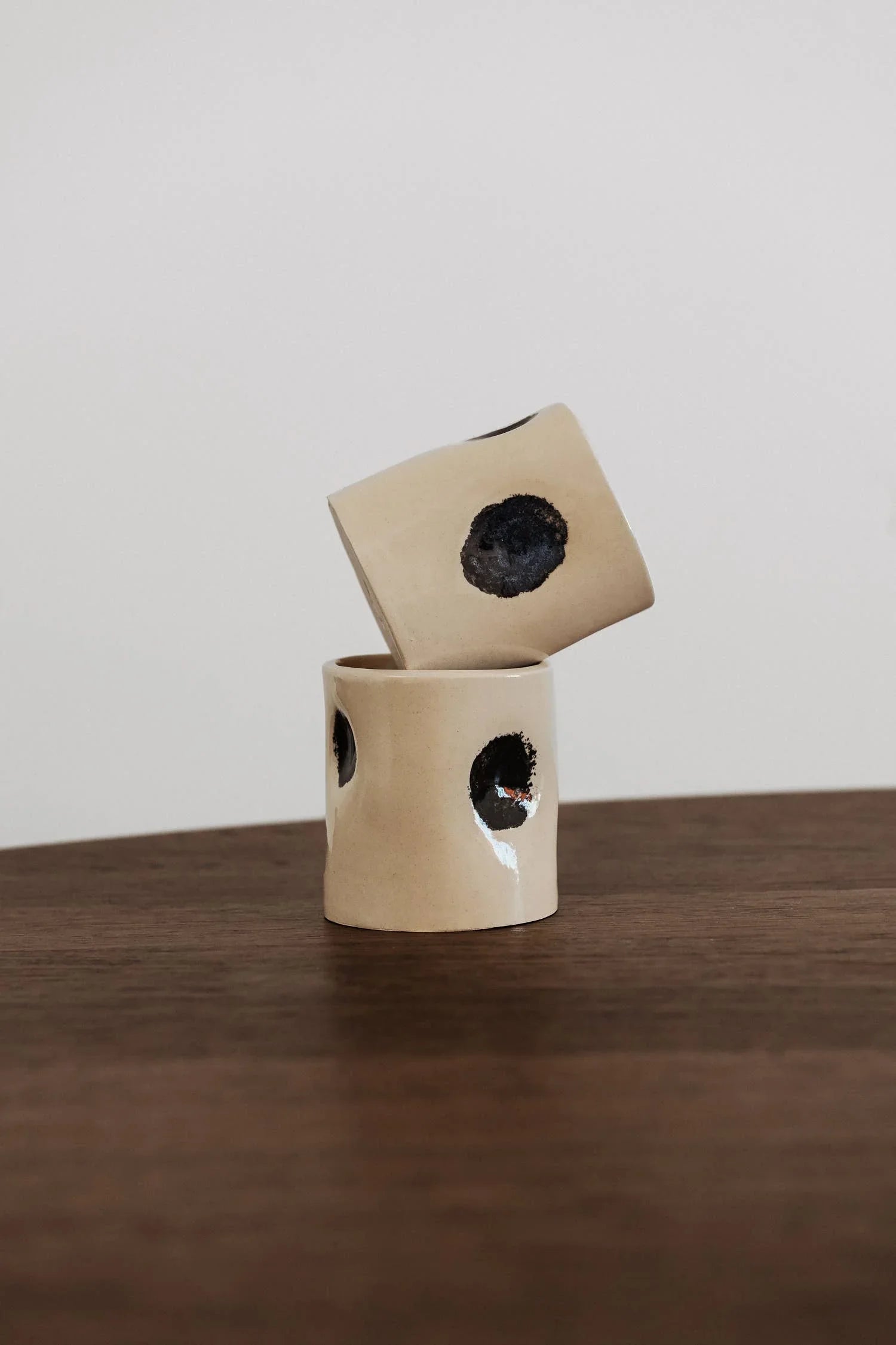 Yunomi ceramic cups with black dots by Sin, stoneware, beige and black, on wooden table