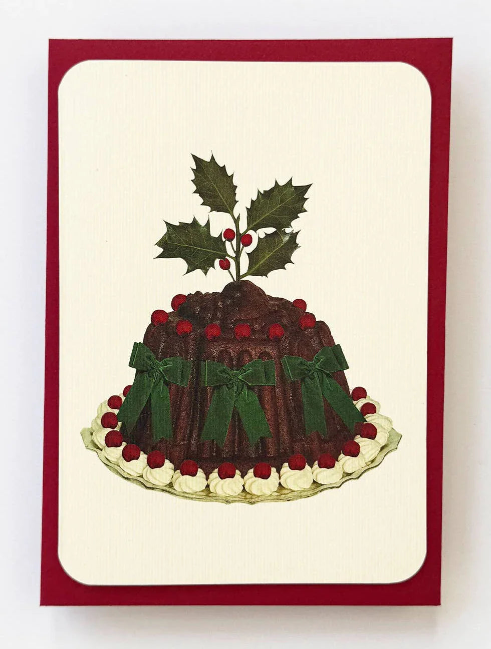 Vintage-style Christmas pudding greeting card with holly, red berries, and green bows on cream cardstock