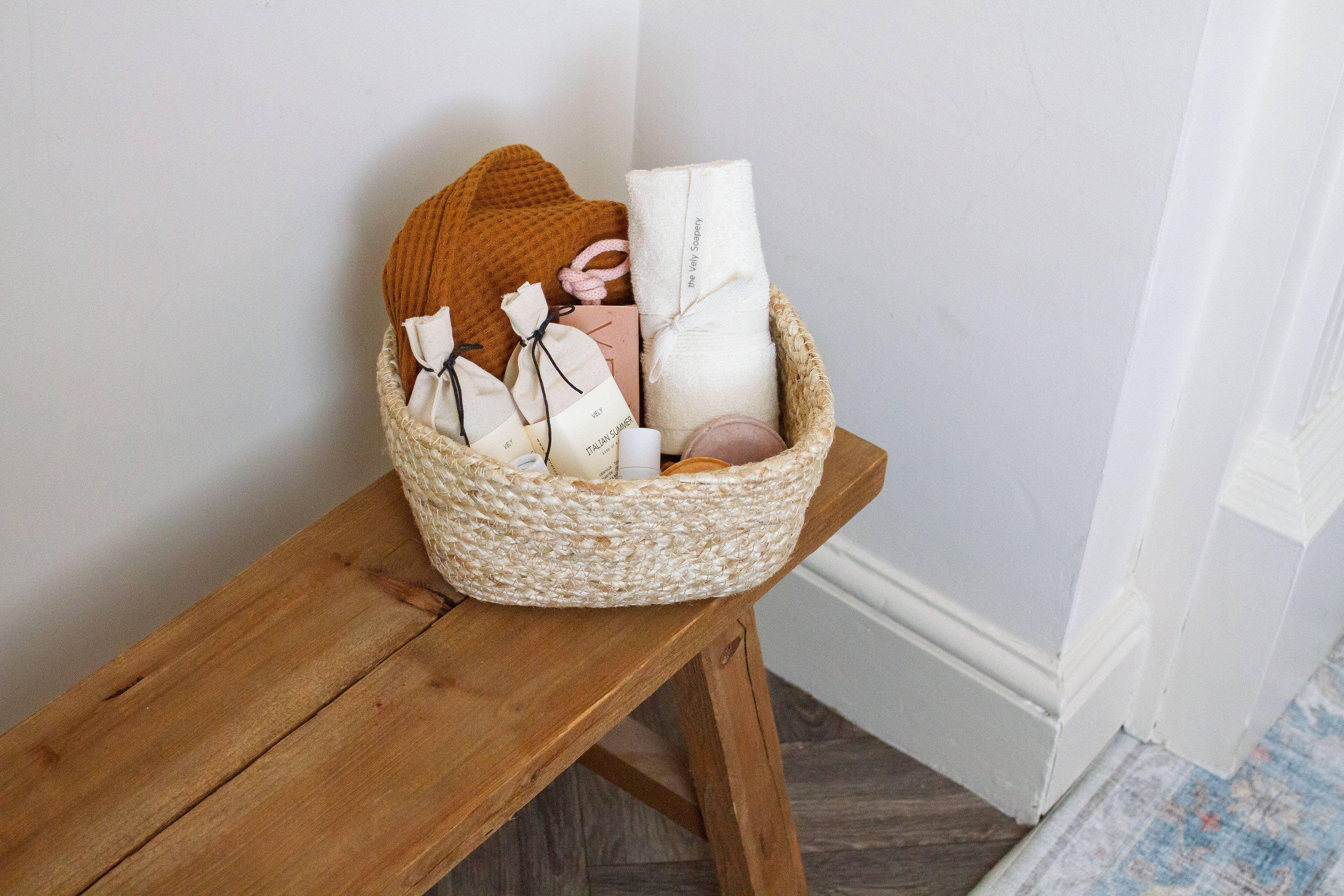 The Key Satoyama gift basket with natural materials, spa products, and neutral colors on a wood bench