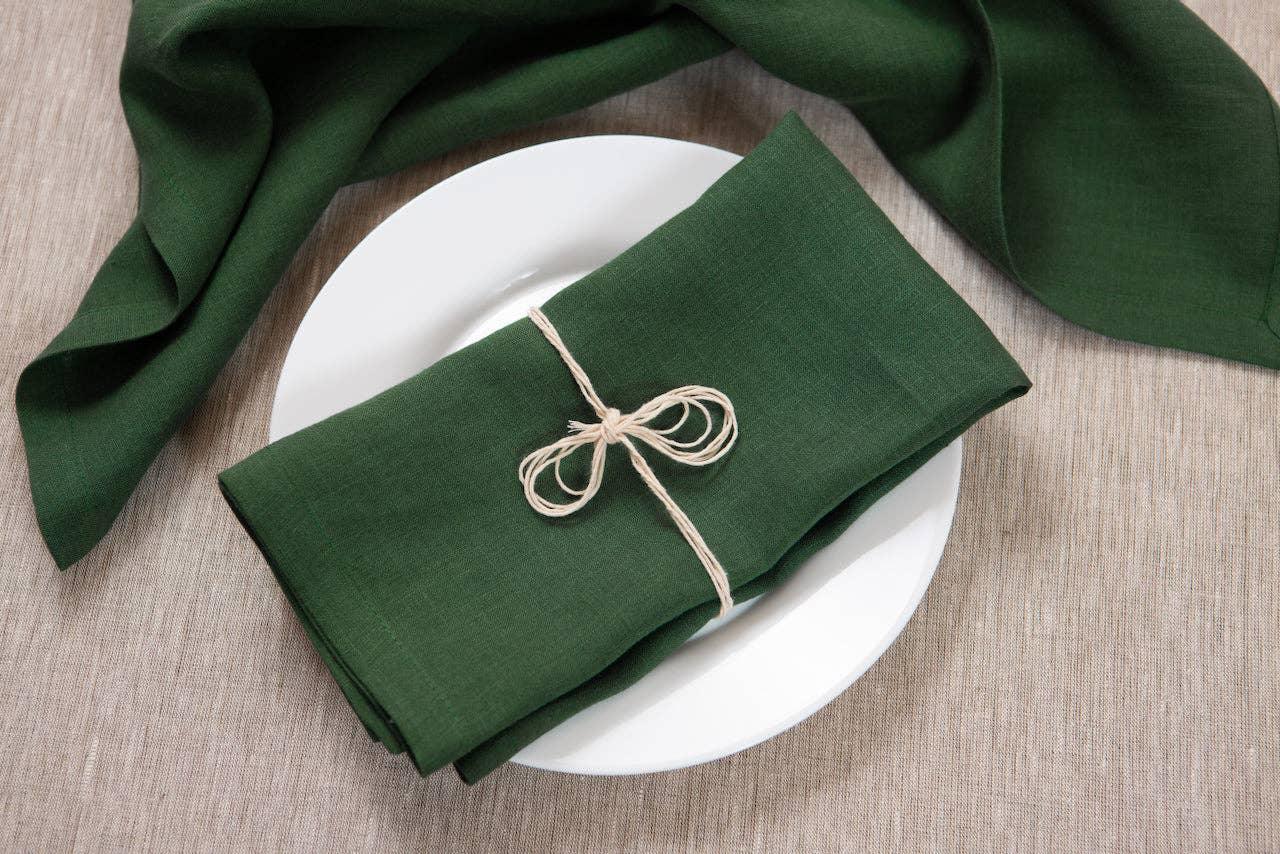 Linen Duet dark green linen napkin set neatly tied on a white plate, premium table decor