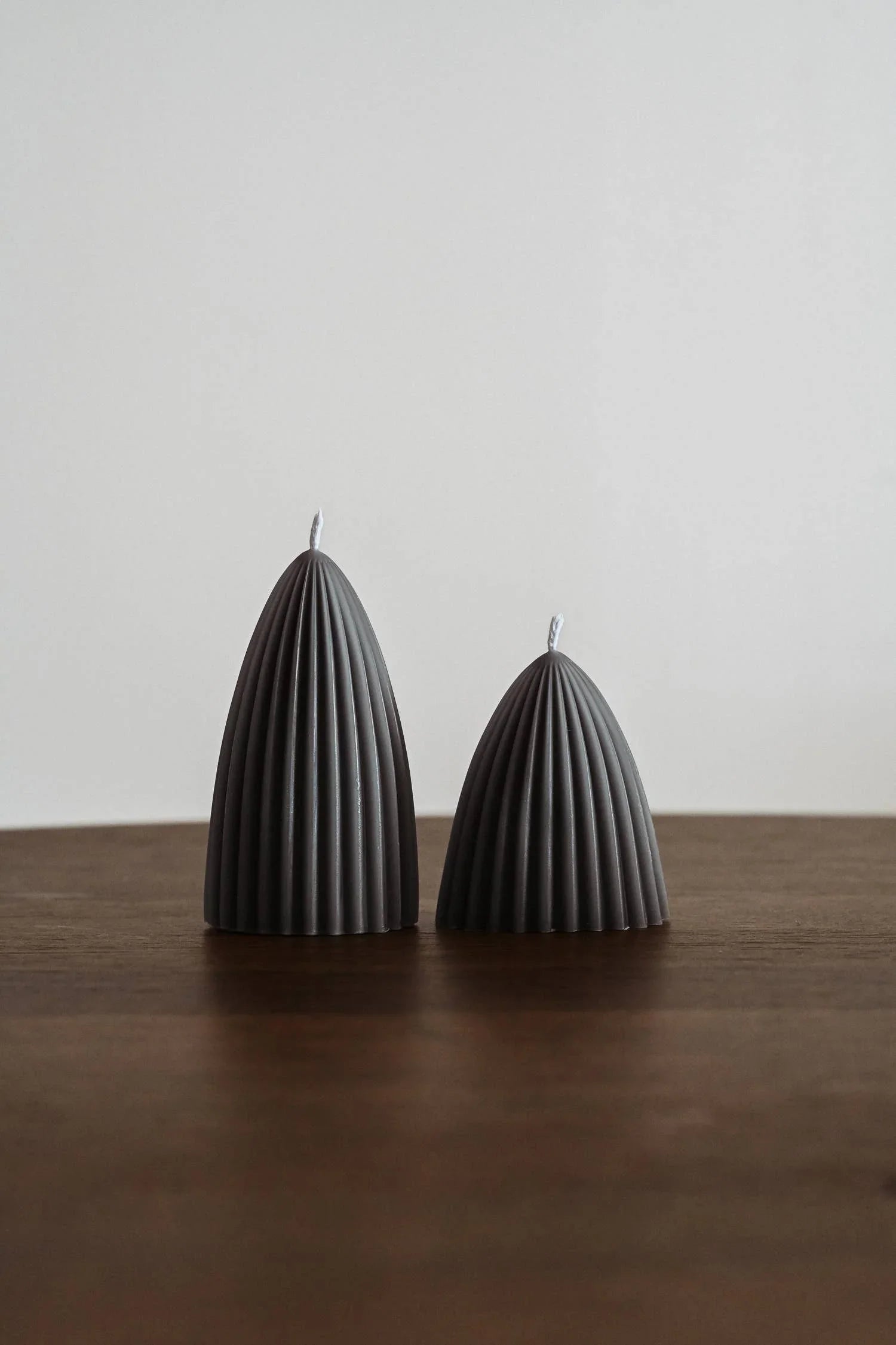Aather grey ribbed soy wax candles set on wooden table, minimal design.