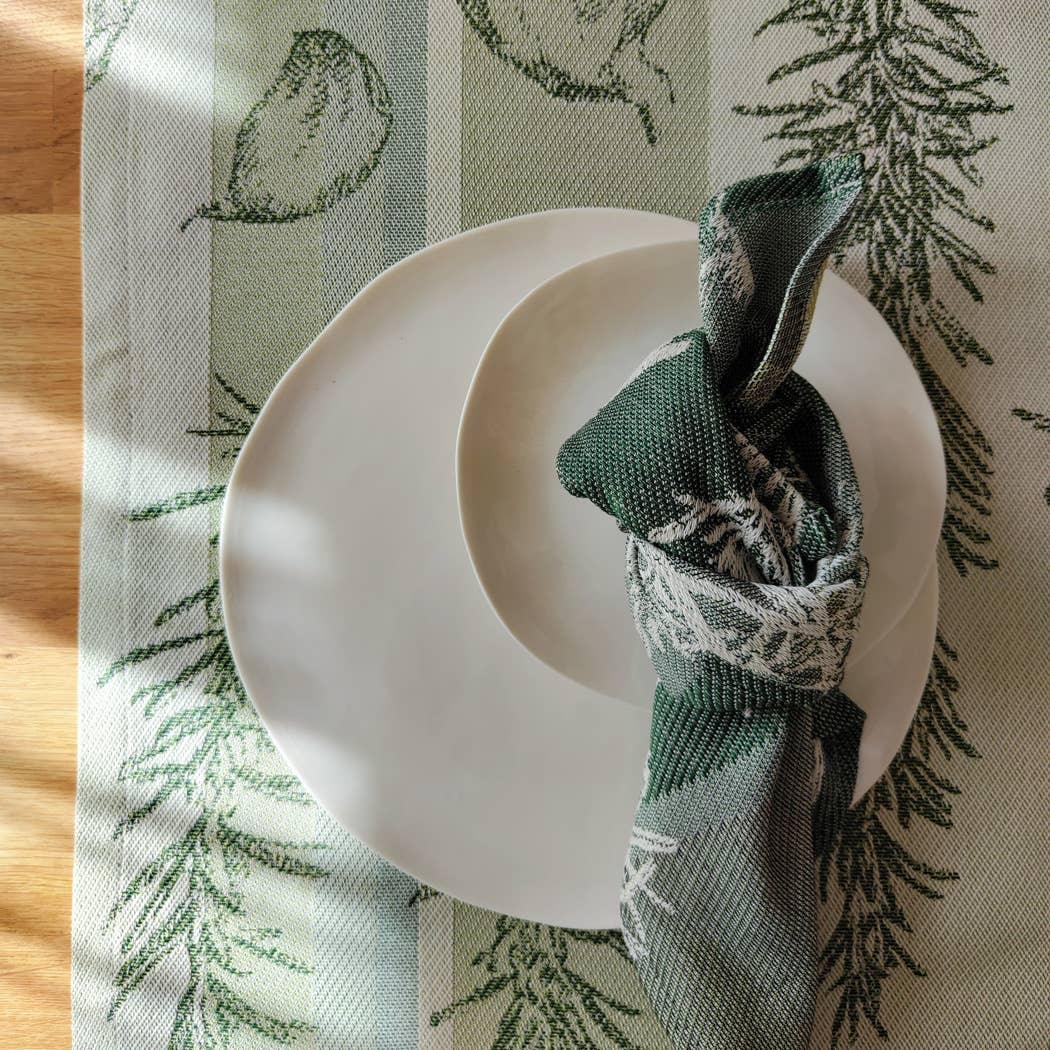 Le Jacquard Français cotton placemat and napkin in green leaf pattern with white ceramic plates
