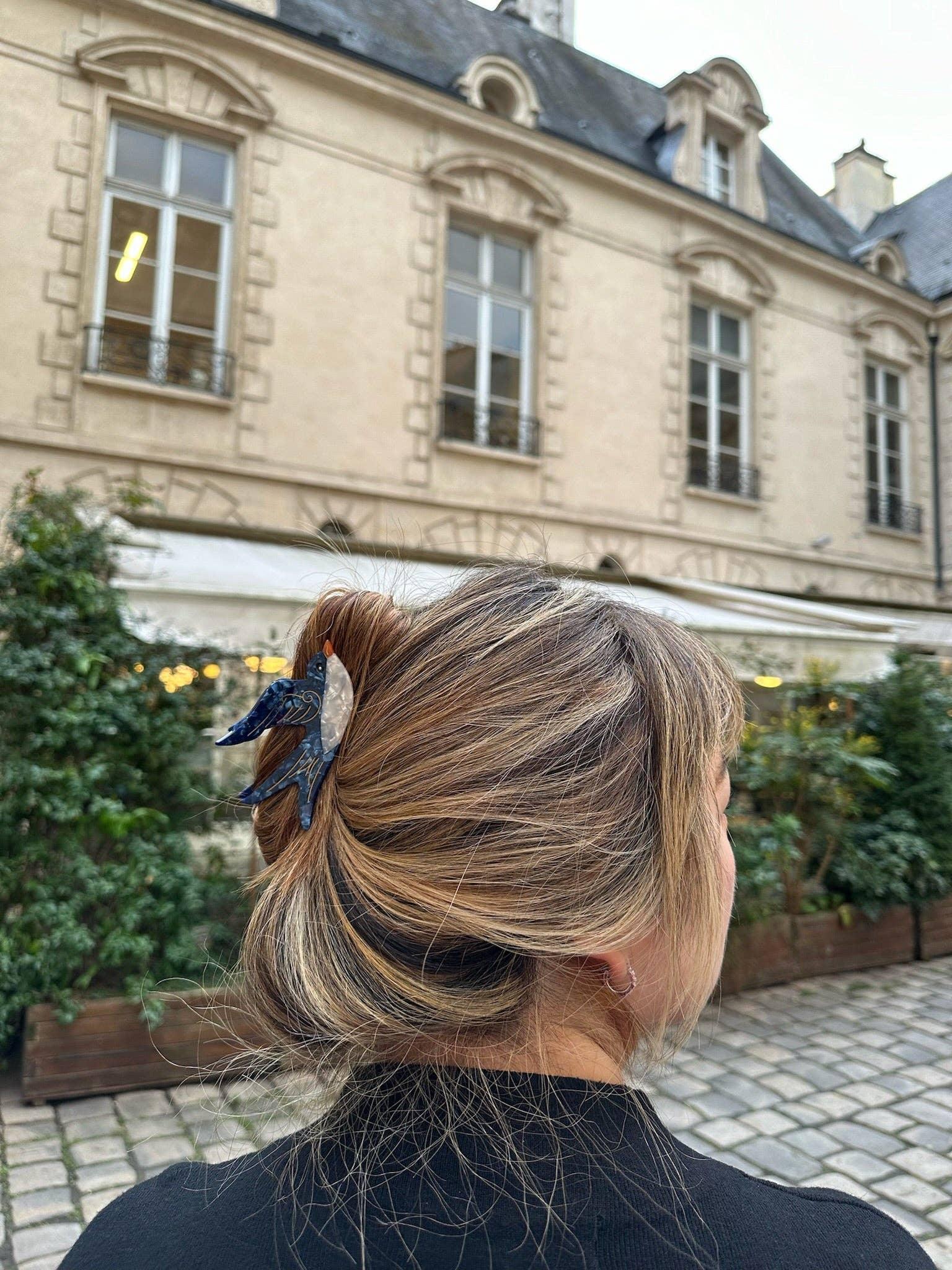 Topologie hair claw in navy and white acetate, worn in blonde hair, outdoor elegant setting