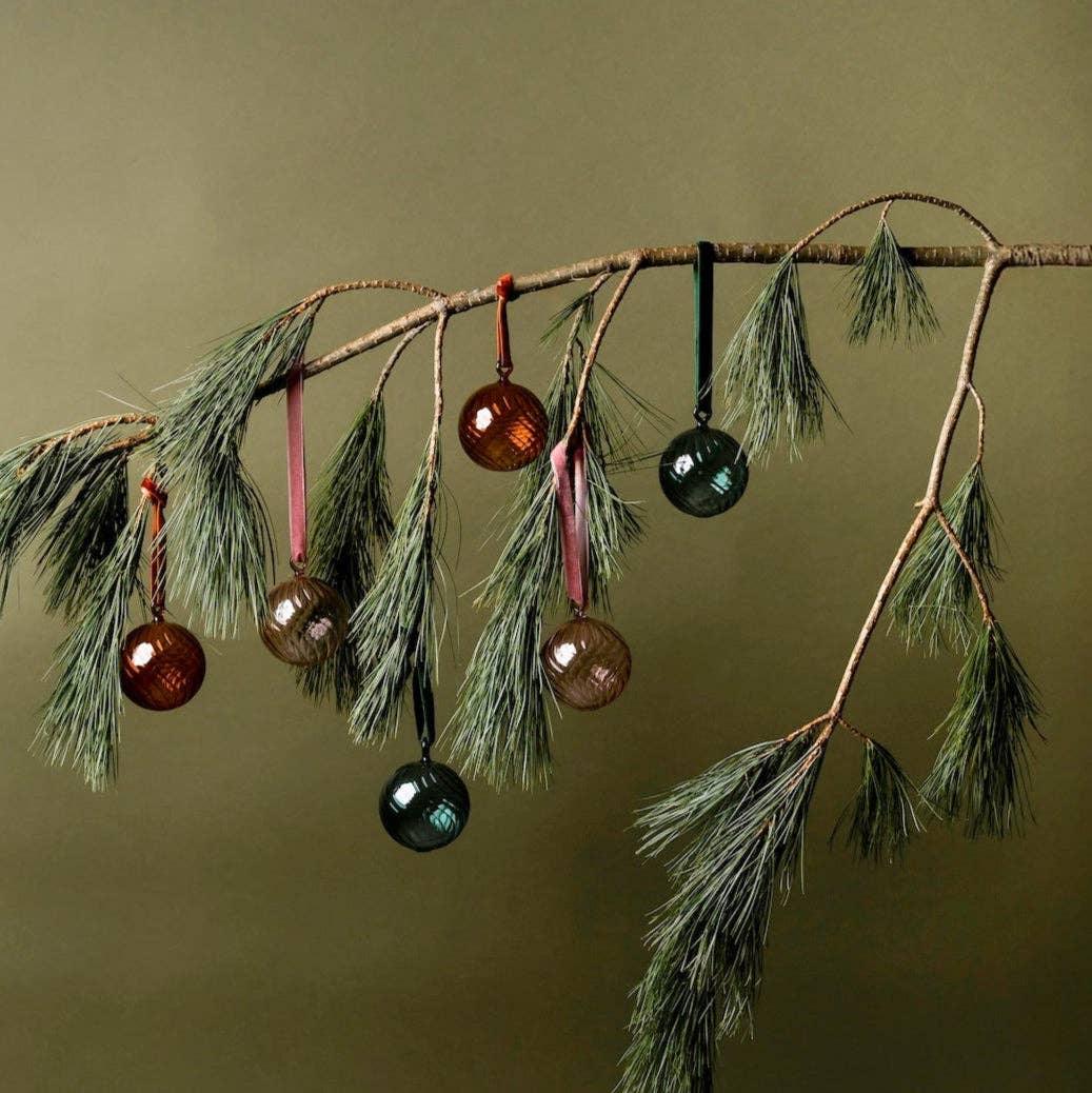 Hubsch glass Christmas ornaments in green and amber on pine branch, premium festive decor