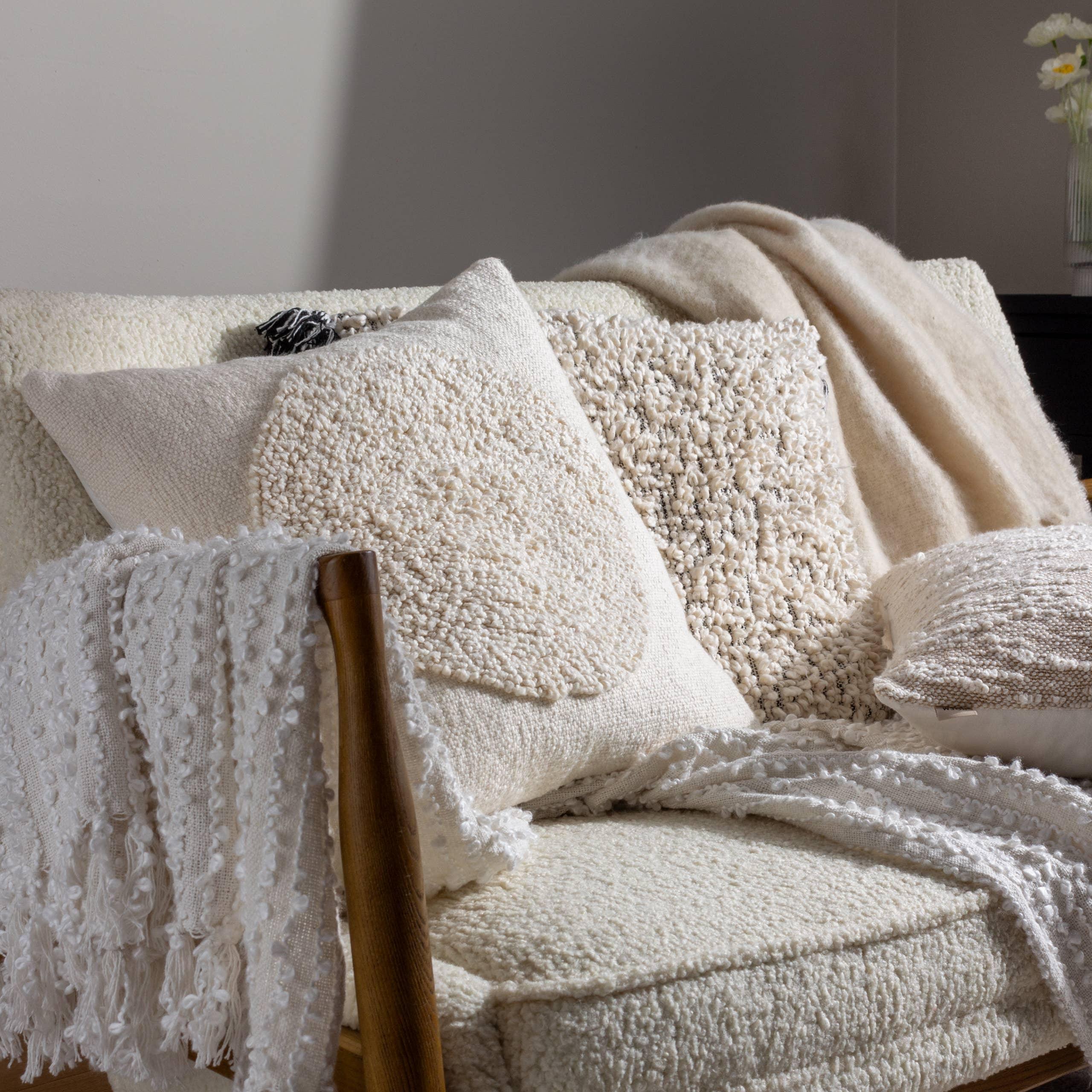 Casa Amarosa cream textured throw pillows and blanket on a boucle sofa