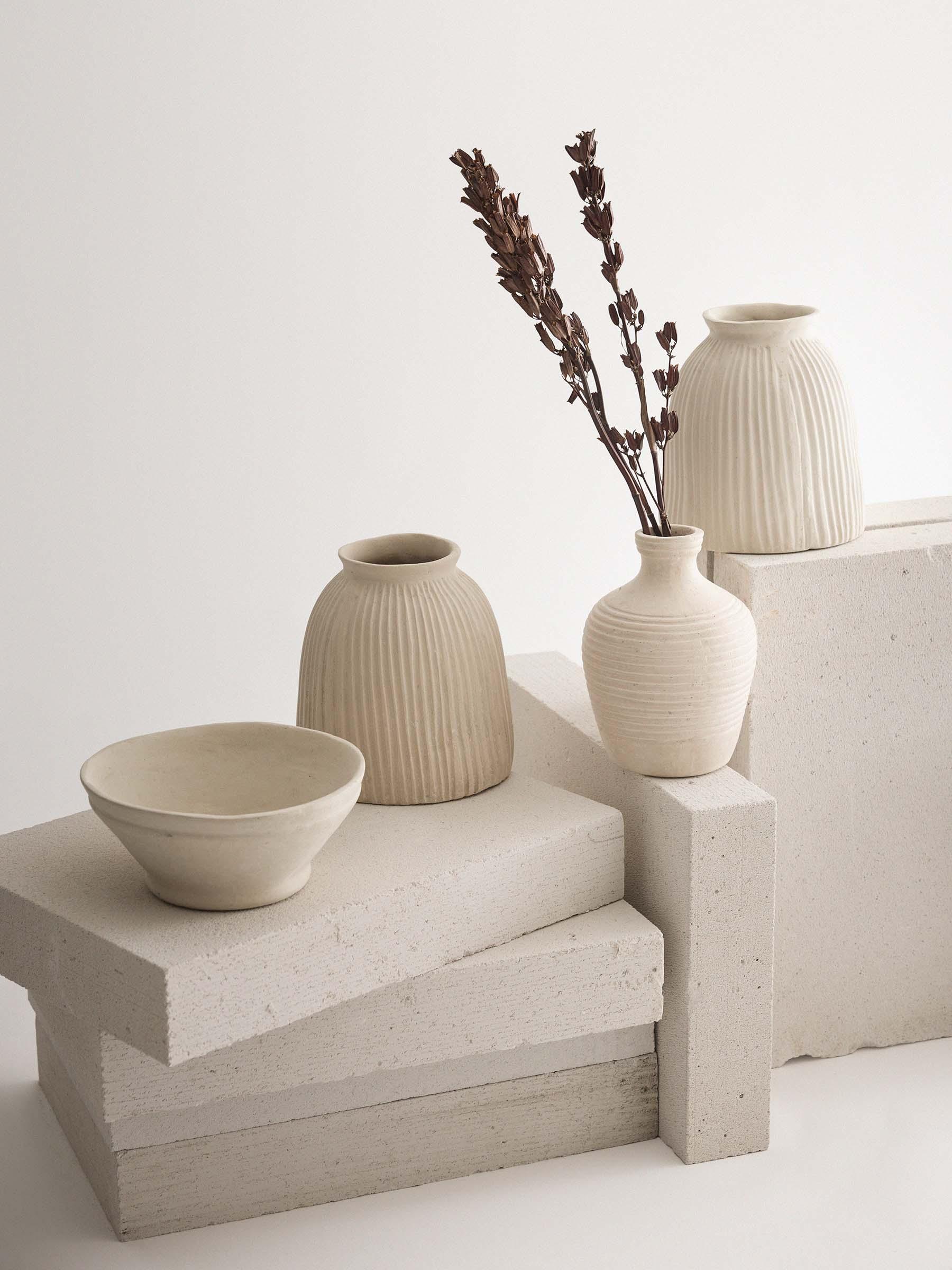 Ferm Living beige ceramic vases and bowl on textured stone blocks, minimal neutral decor