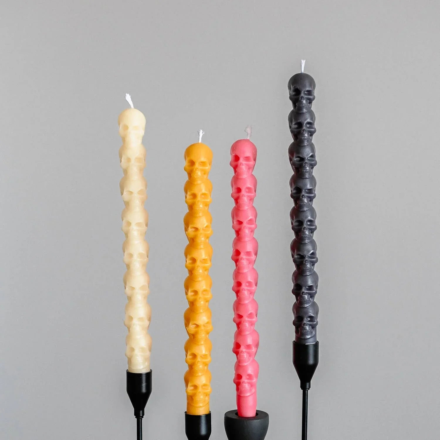 CandleHand skull taper candles set, beeswax, cream, yellow, pink, black, on gray background