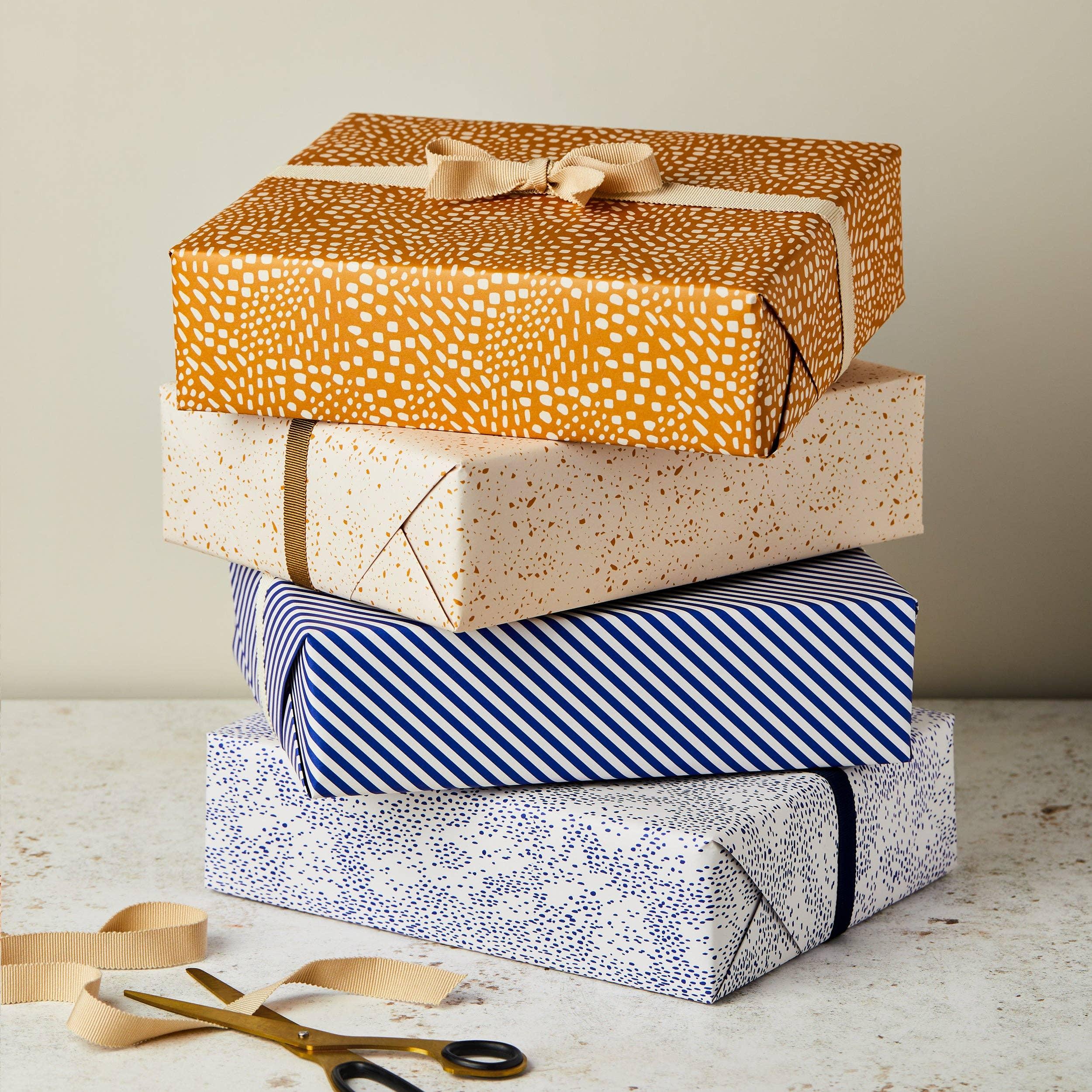 Rifle Paper Co. premium gift wrap, assorted patterns, high-quality paper, blue and gold.