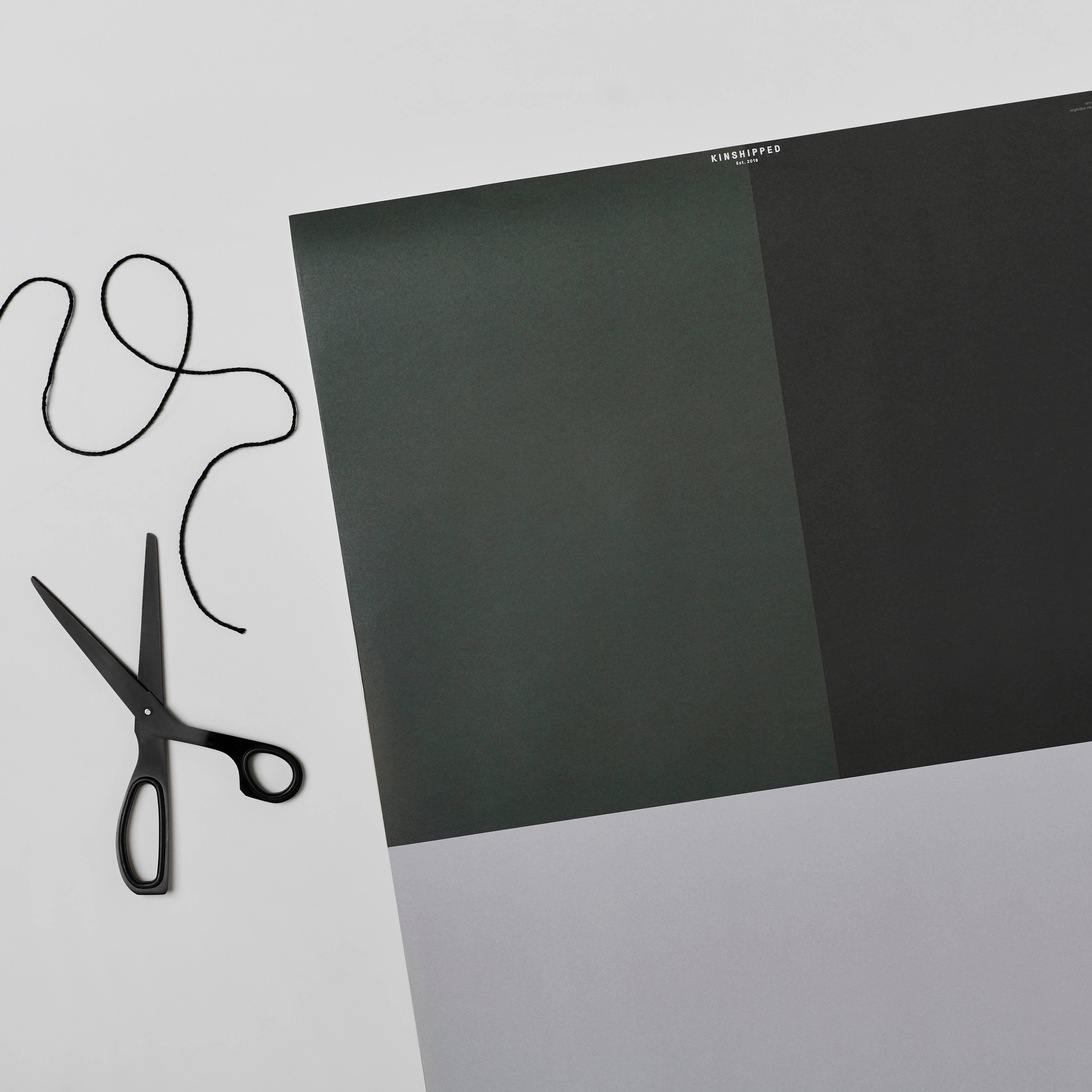 KINSHIPPED luxury wrapping paper in green, black and grey with black scissors and string