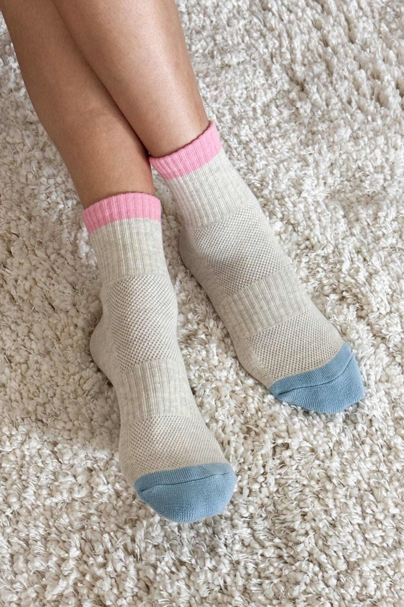 Le Bon Shoppe cotton socks in cream with pink cuffs and blue toes on plush rug
