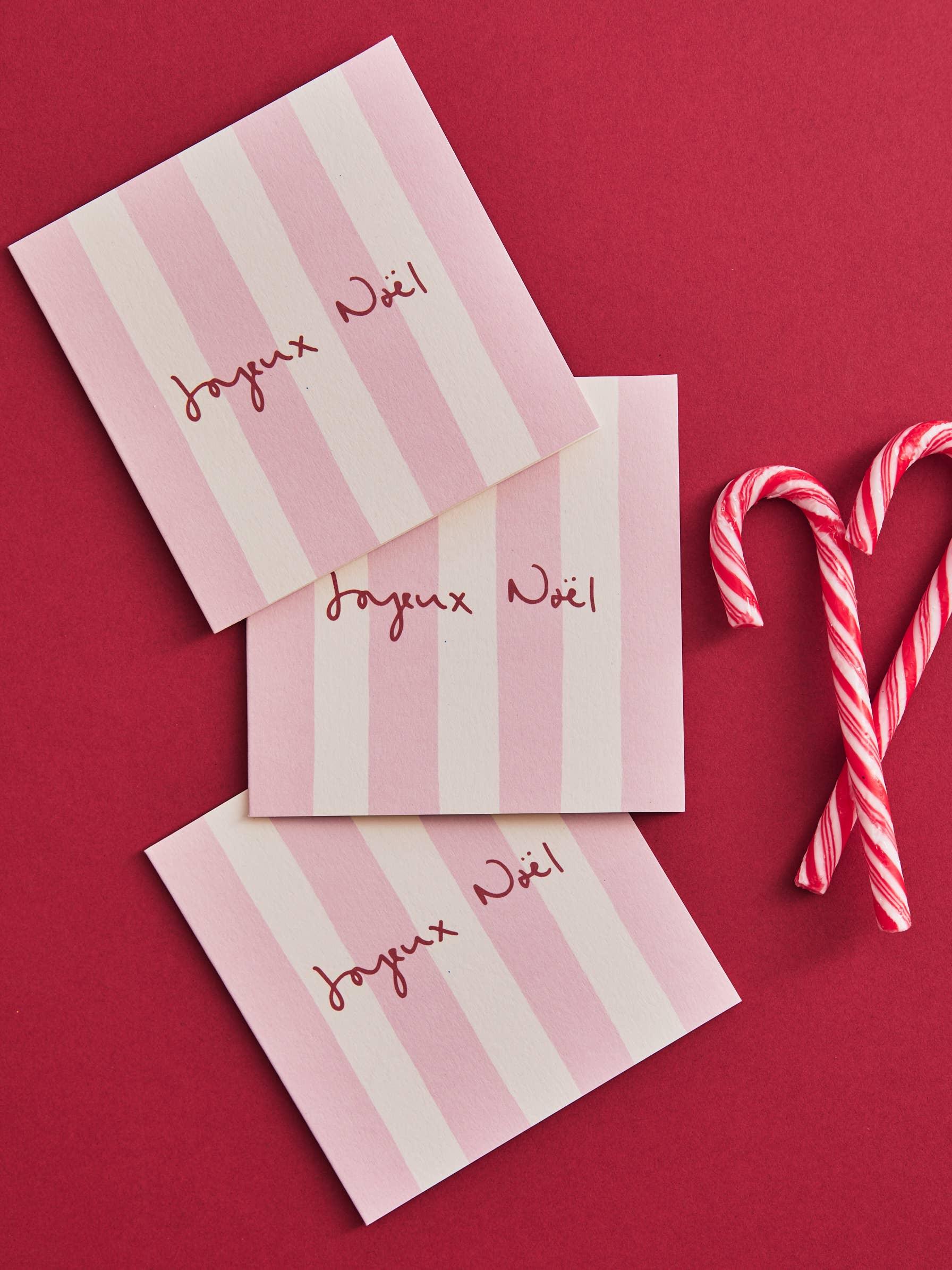 Moglea pink striped Joyeux Noël cards on red background with candy canes, premium cardstock.