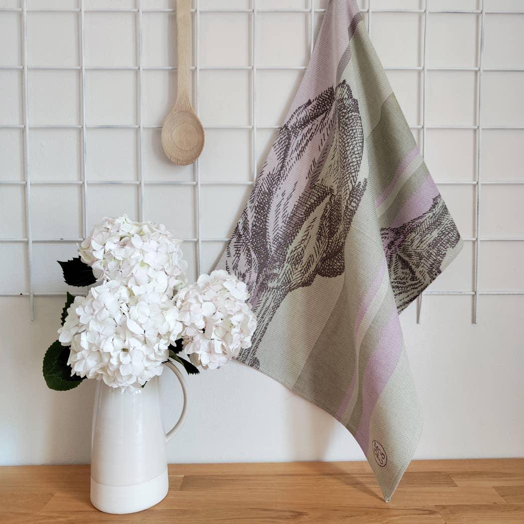 Stetson linen-cotton tea towel in sage and lilac with floral print, hanging in modern kitchen.