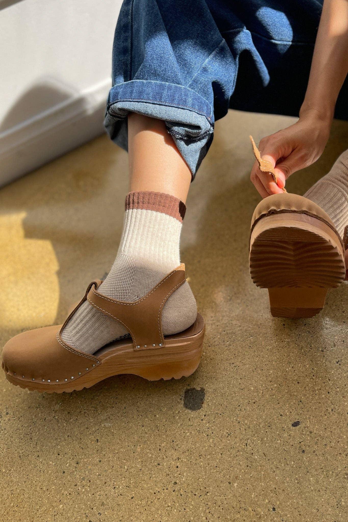 Bryr tan leather clog sandals with wooden sole, worn with neutral socks and blue jeans