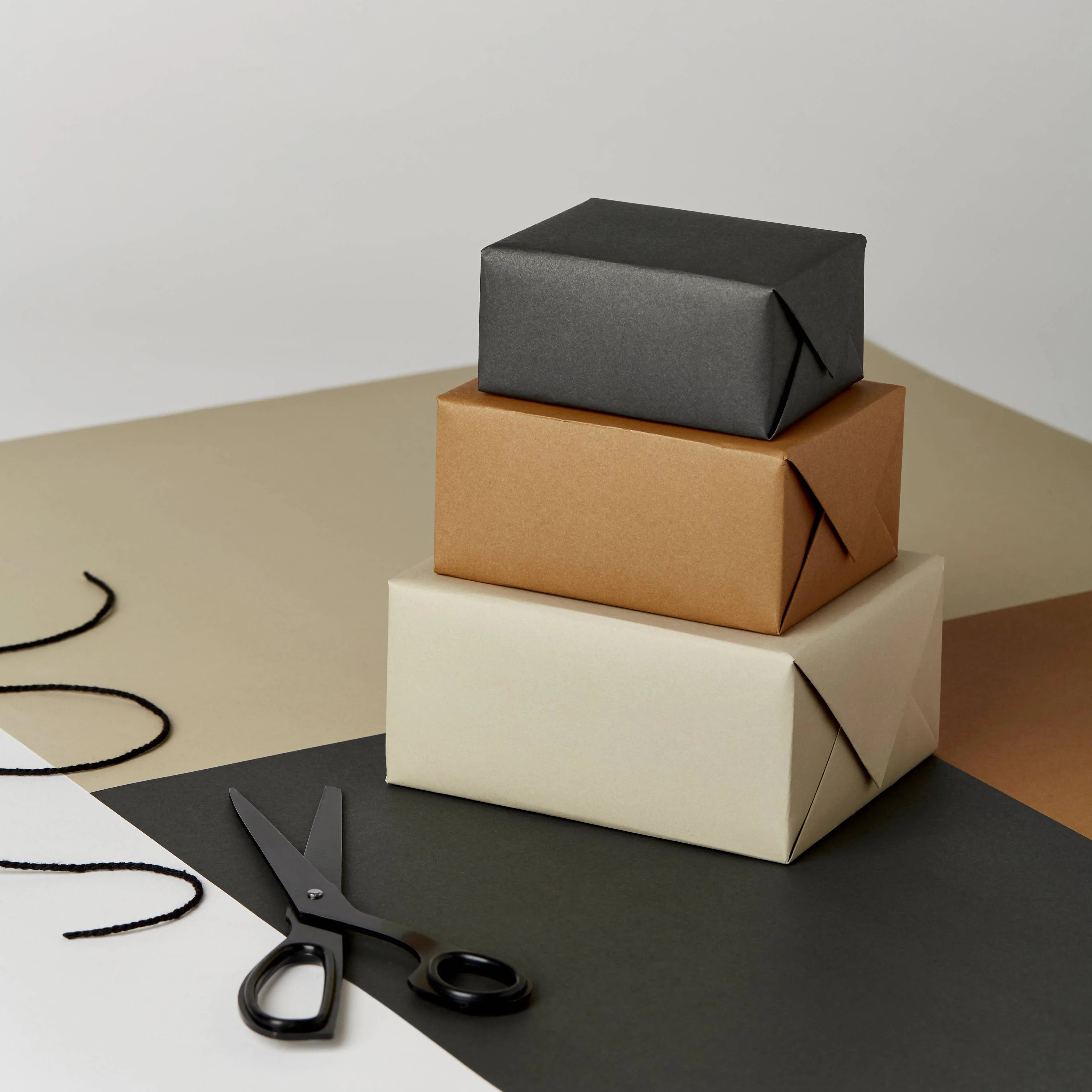 Present and Correct gift boxes in black, kraft, and cream paper with black scissors