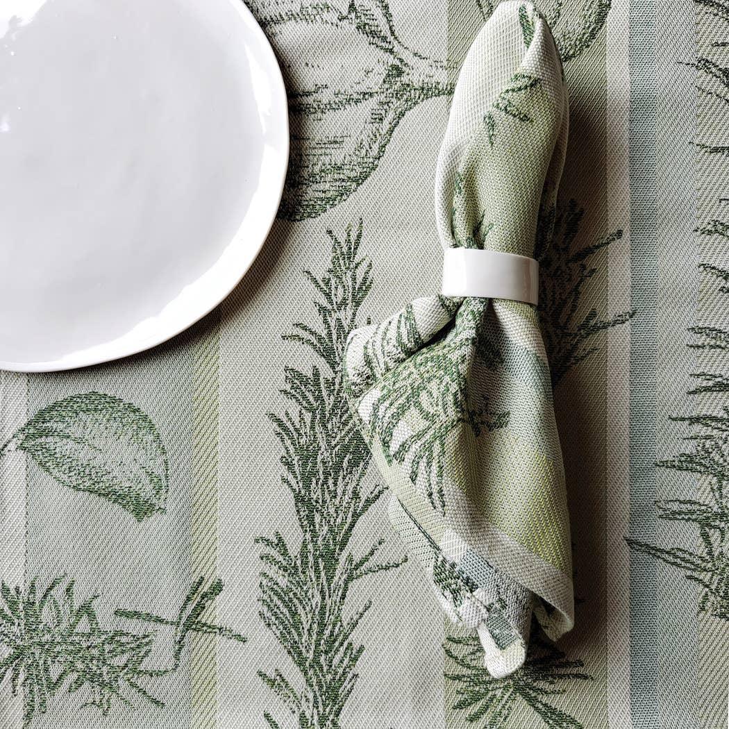 Garnier-Thiebaut botanical jacquard linen napkin in green with white napkin ring and plate