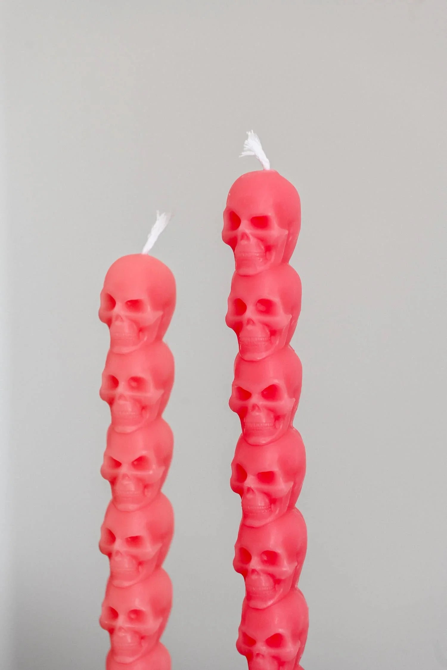 Lohn pink skull-shaped decorative candles, stacked wax design, minimalist background