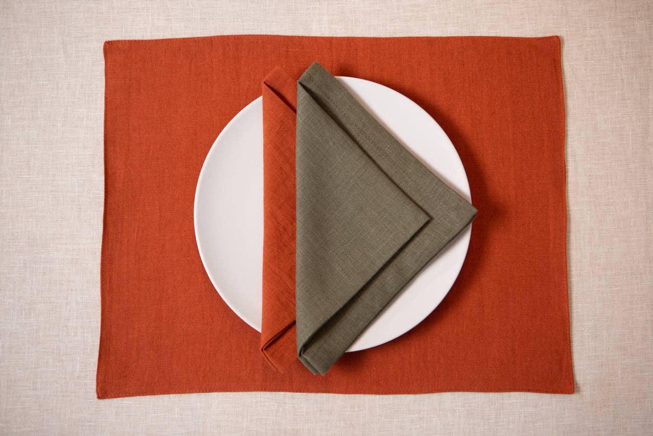 Maison Septembre linen placemat in rust orange with olive green linen napkin and white plate