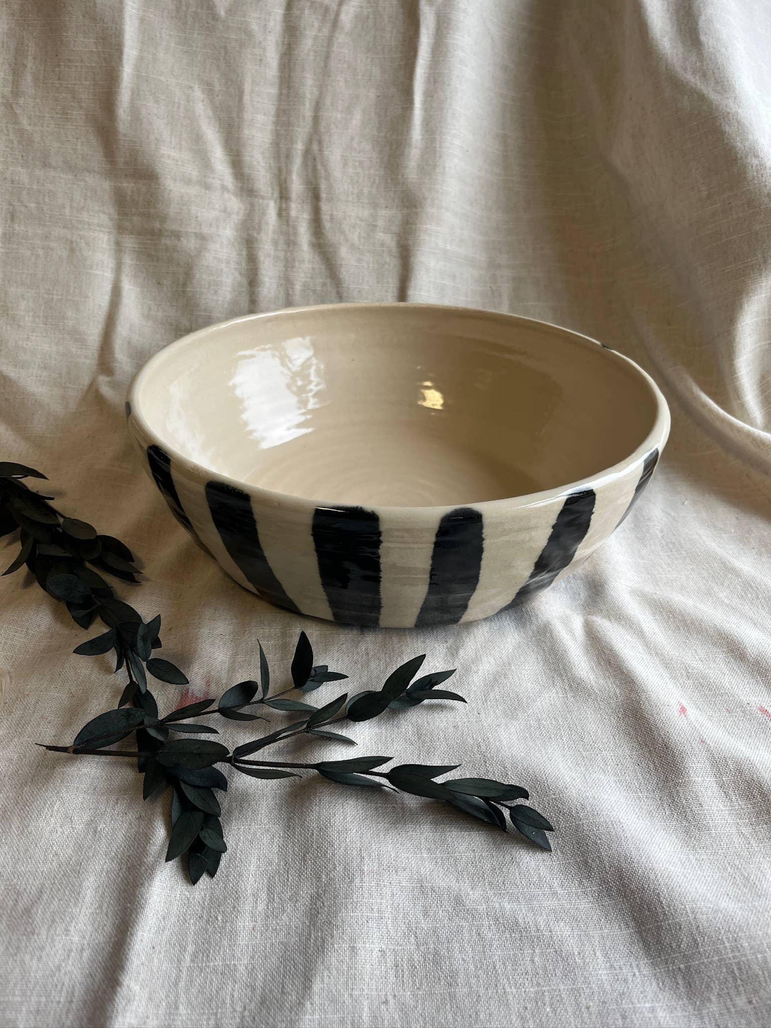 Lucy Burley ceramic bowl, cream with black stripes, handmade pottery on linen cloth