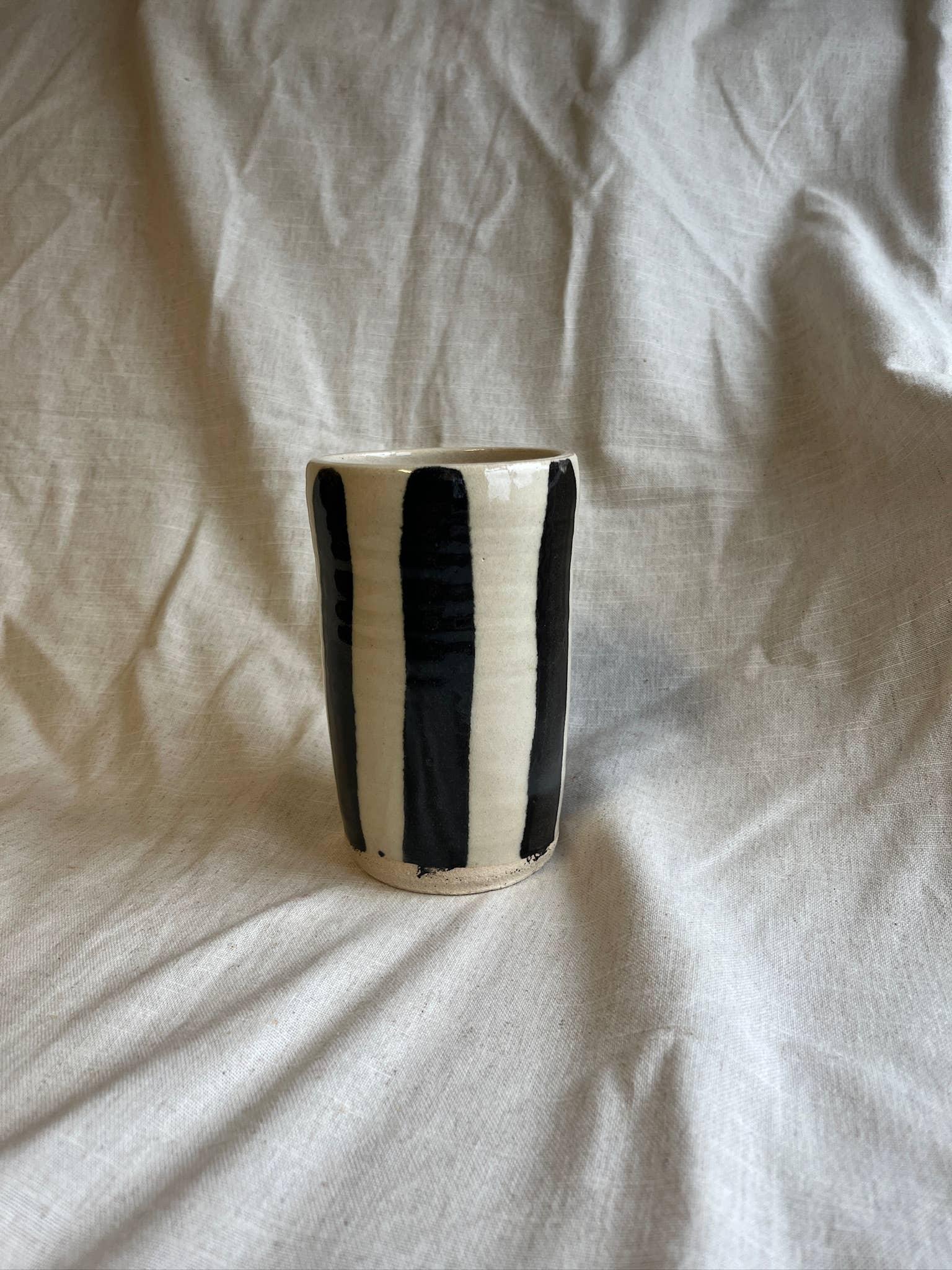 Wife Ceramics handmade stoneware tumbler, black and white striped, on linen backdrop