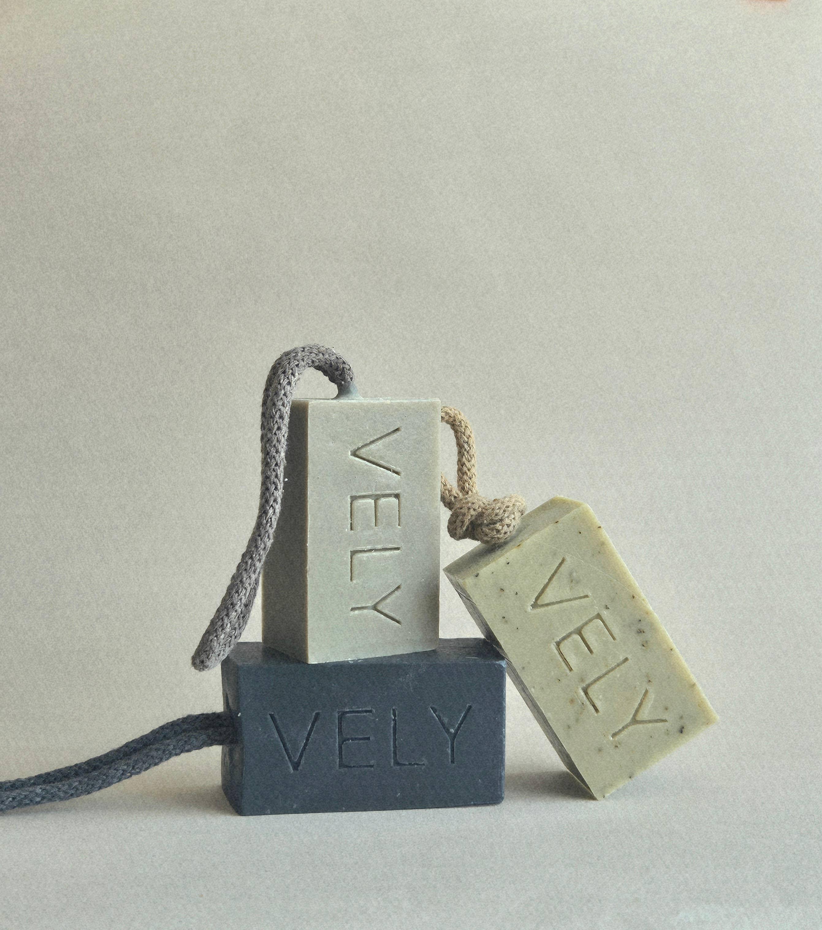 VELY handmade soap bars in grey, green, and beige with rope handles, stacked minimalist