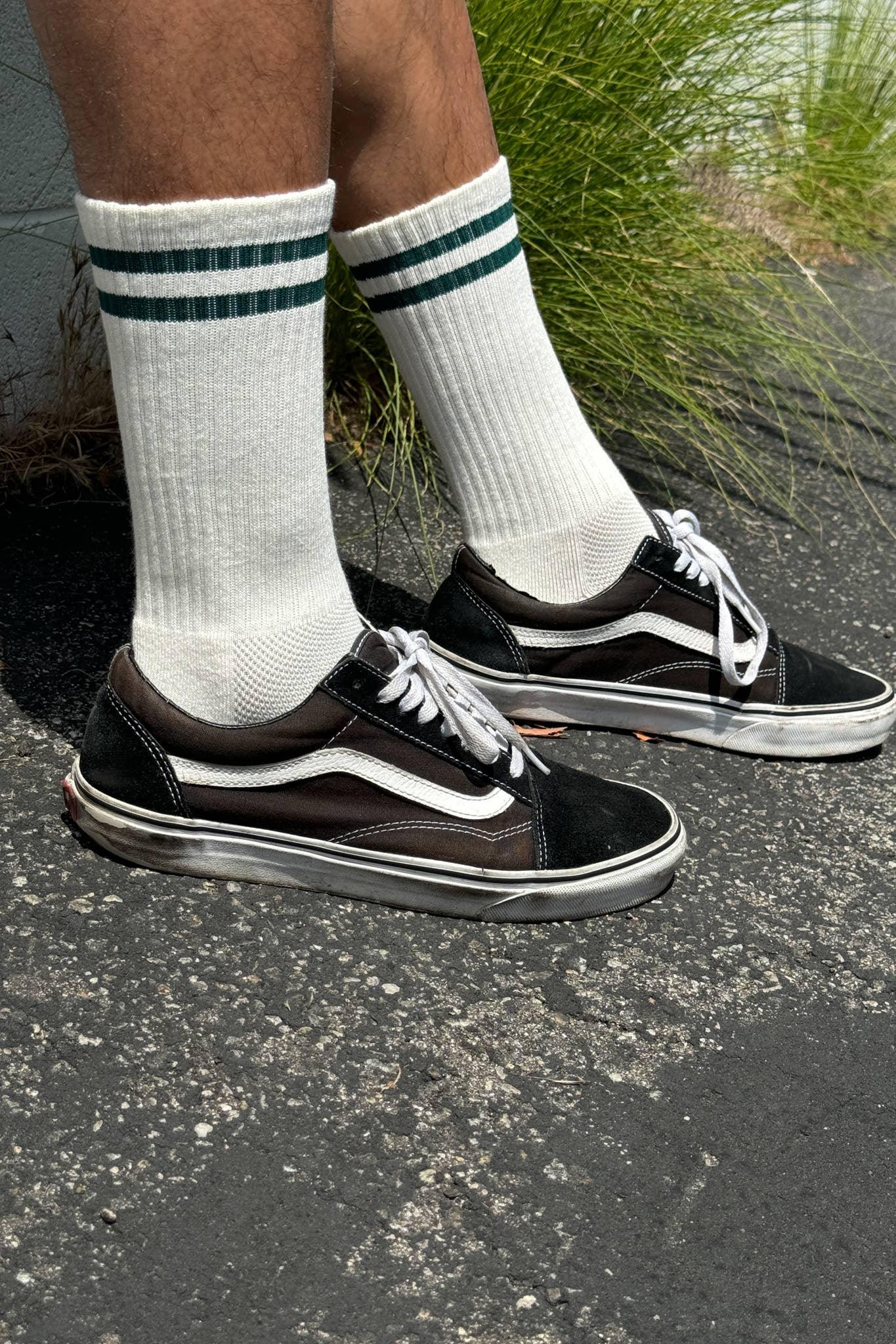 Vans Old Skool black suede canvas sneakers with white stripe, worn with white ribbed socks