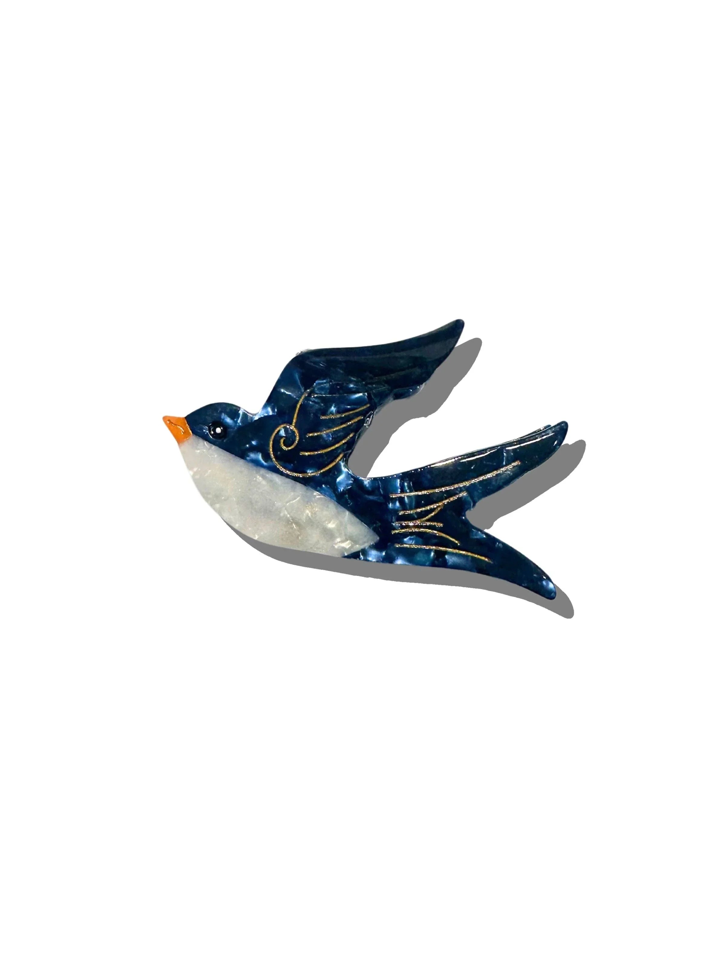 Nagisa Art blue and white enamel swallow brooch with gold accents on white background