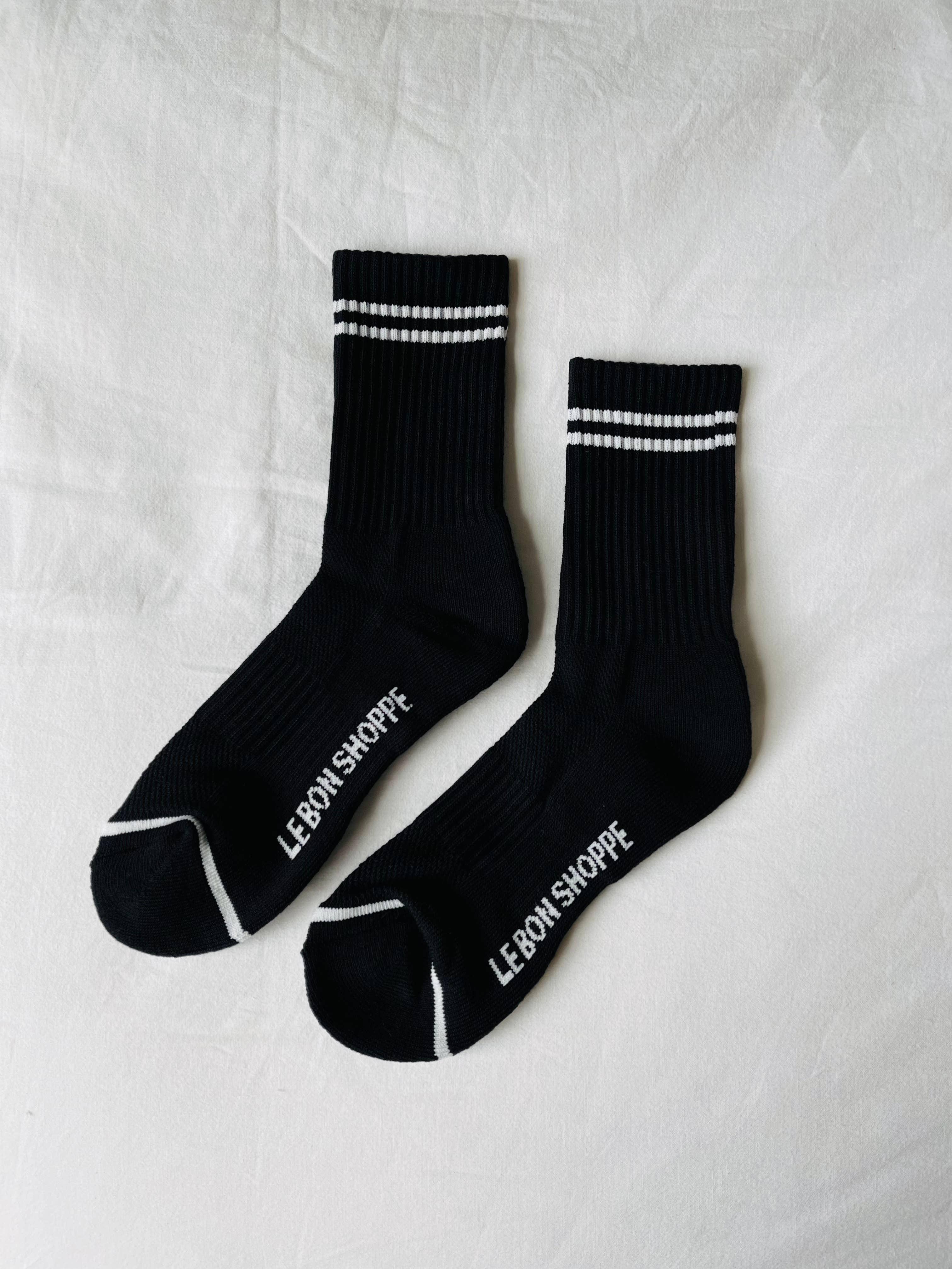 Le Bon Shoppe black cotton socks with white stripes and logo on white background