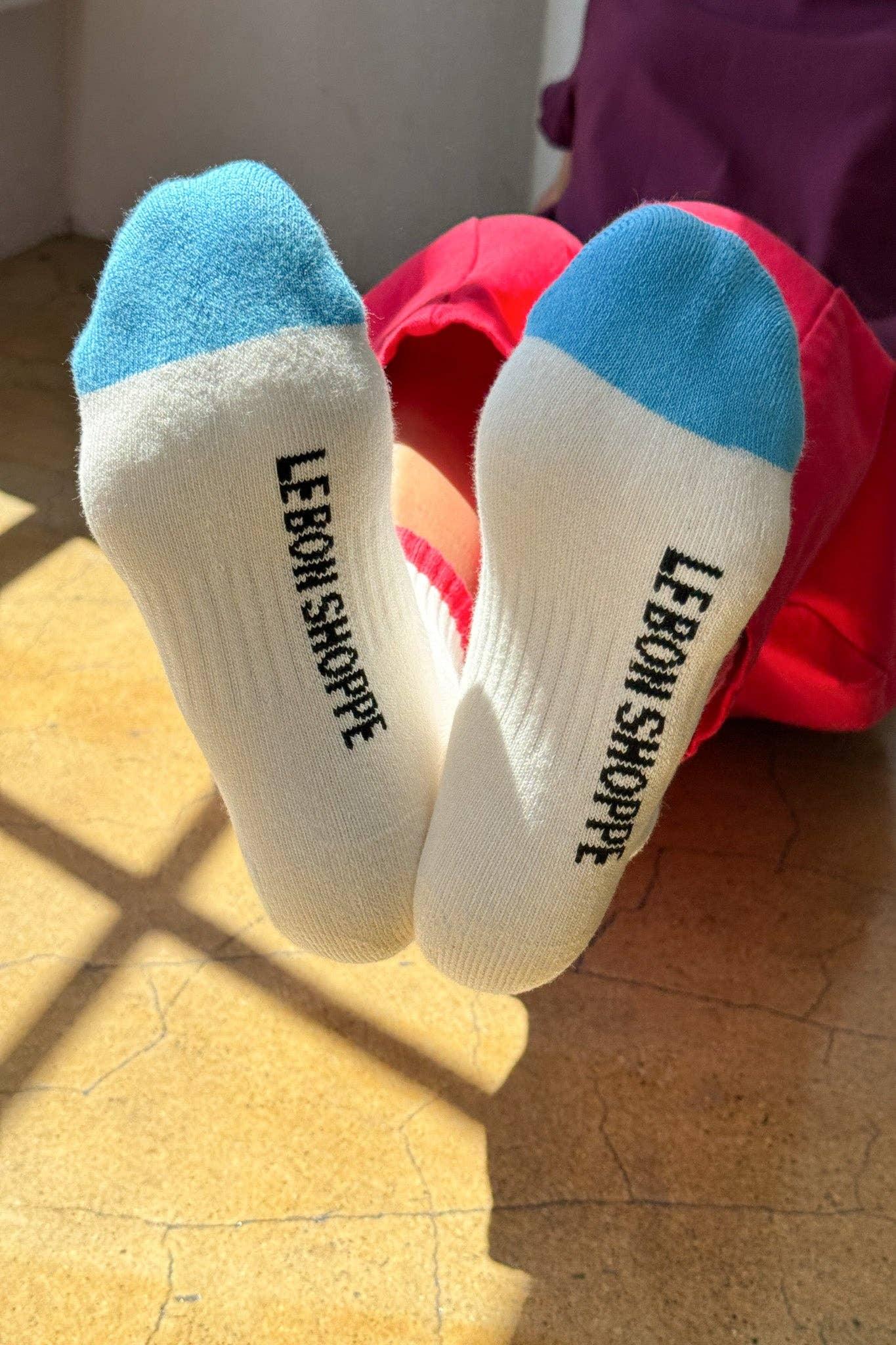 LEBON SHOPPE premium cotton blend crew socks, white with blue toes, sunlit indoor setting.