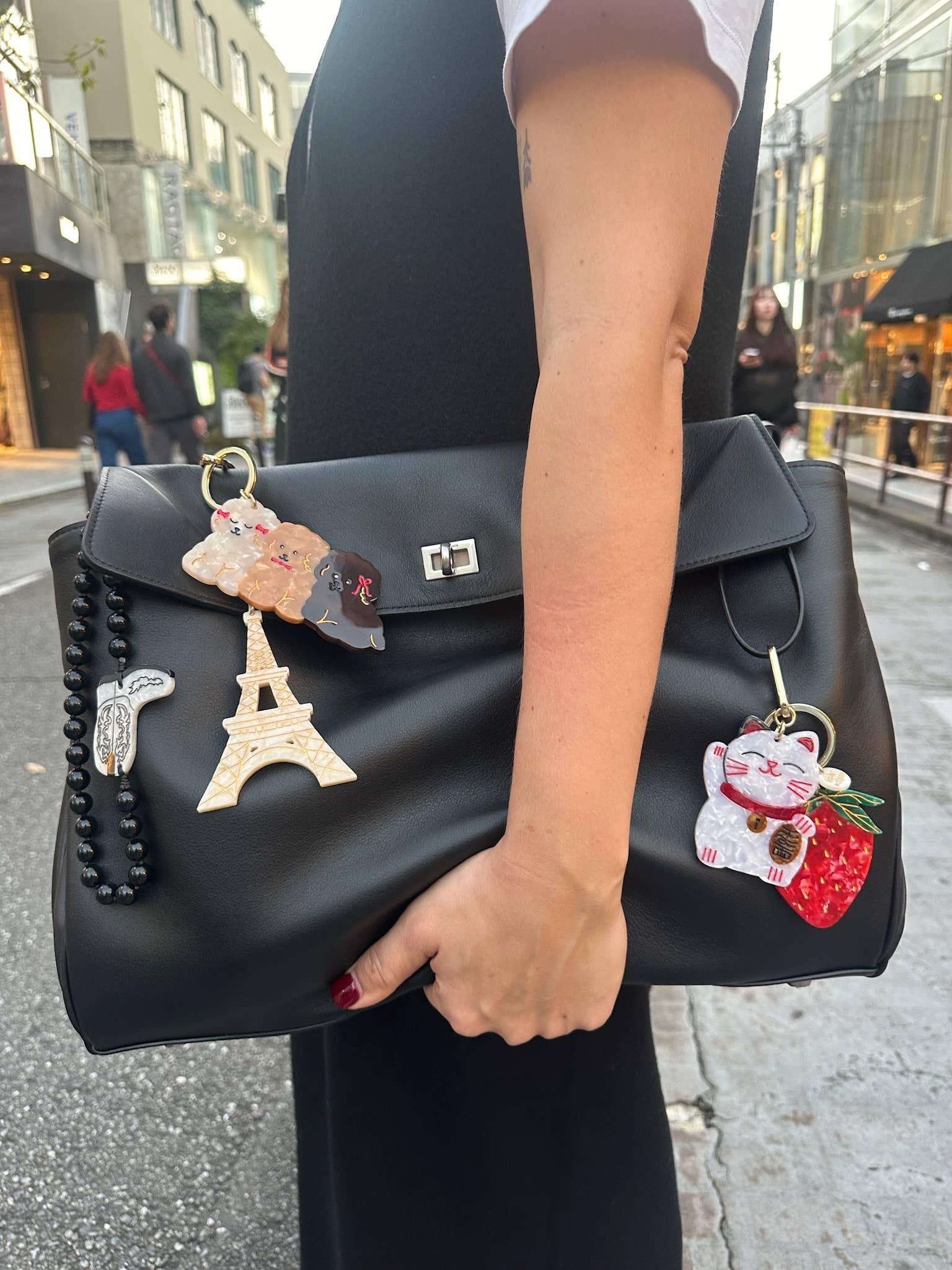 Hermès black leather handbag with acrylic Eiffel Tower, dog, cat charms and black bead strap