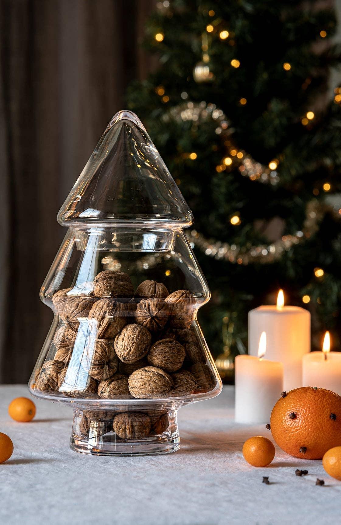 Schott Zwiesel glass Christmas tree jar filled with walnuts, candles and fruit nearby