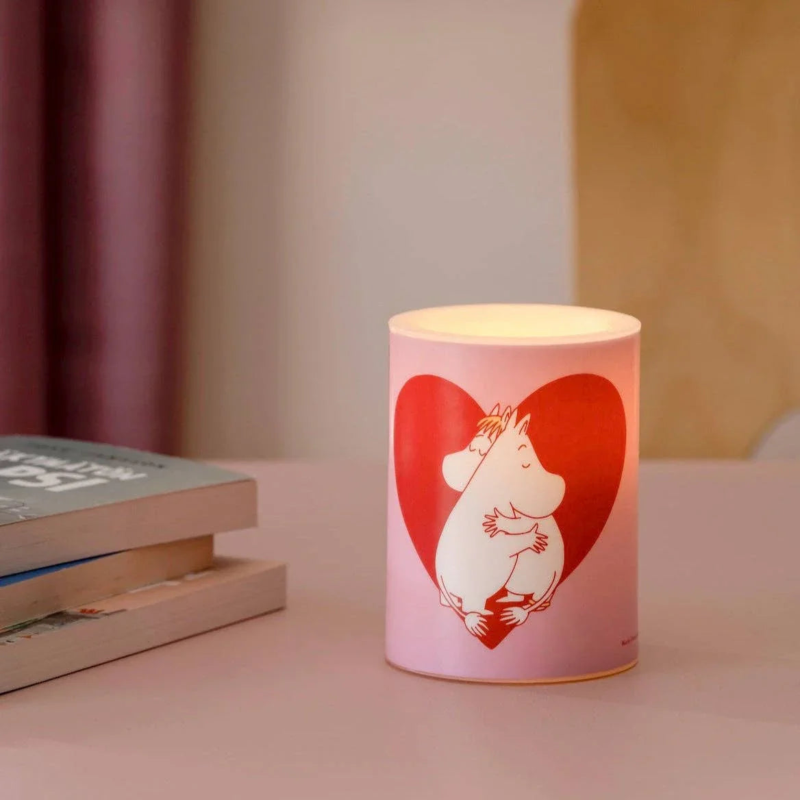 Moomin pink ceramic candle holder with red heart design on a table, premium decor