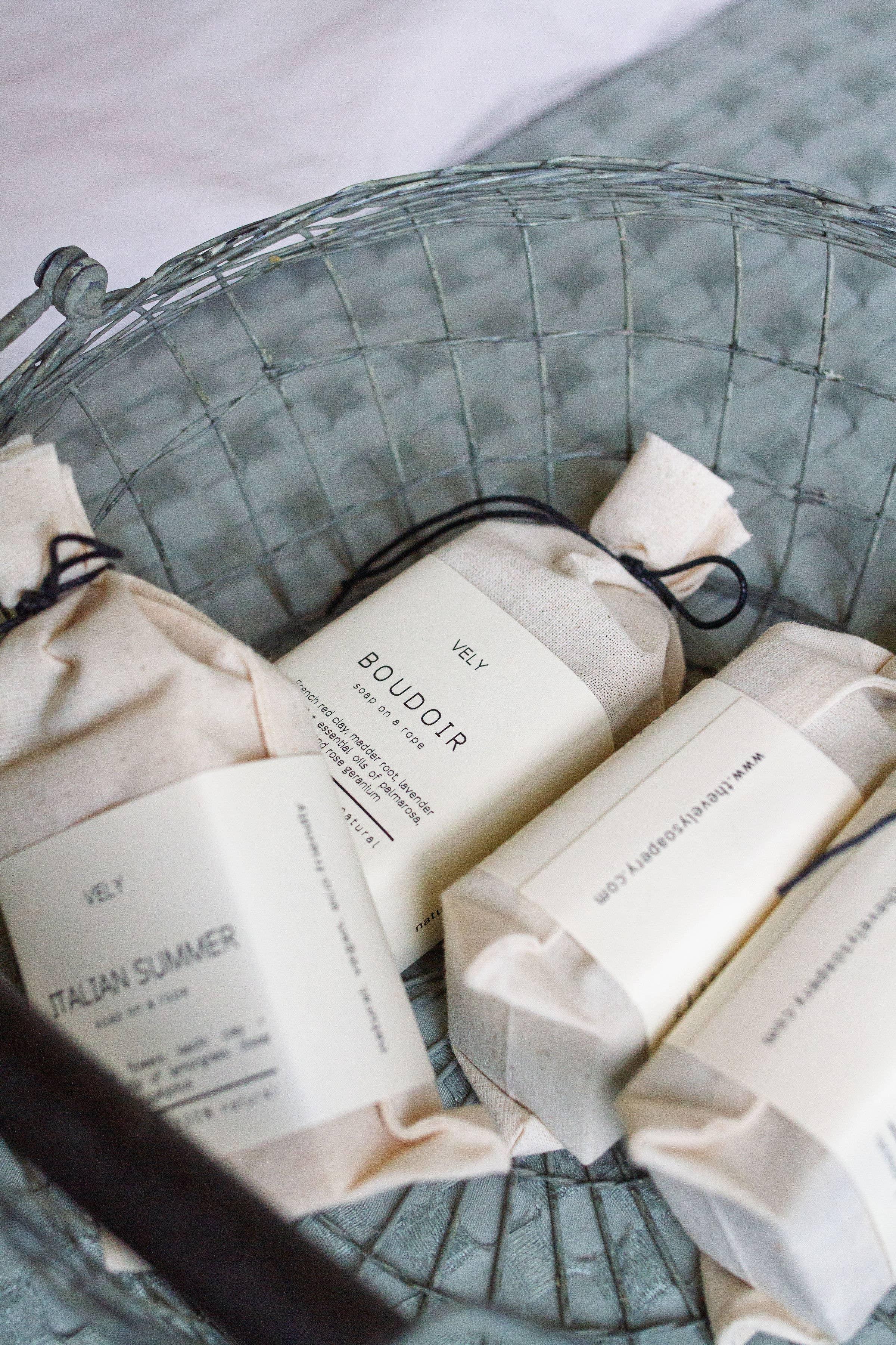 VELY artisanal soaps in cream cloth packaging in metal basket, premium natural bath products