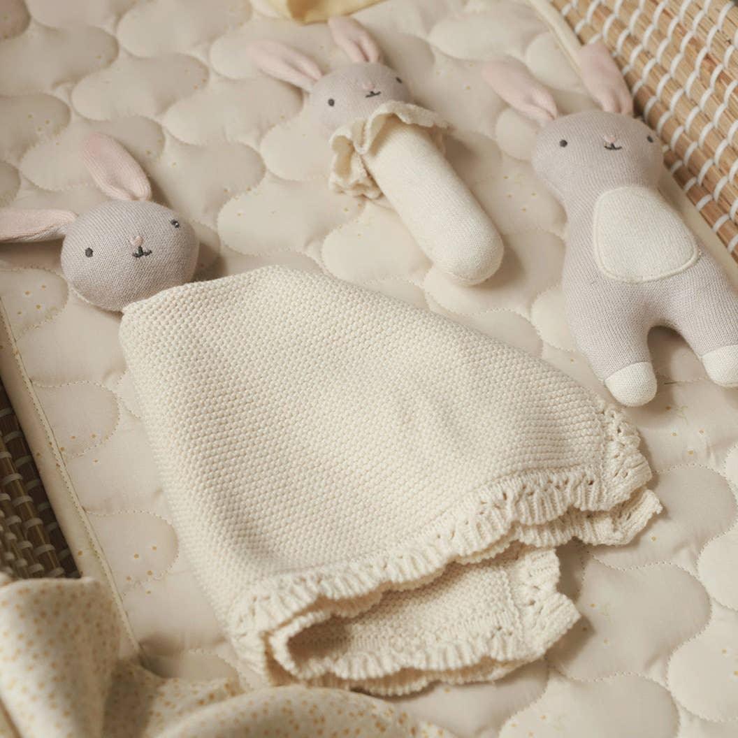 Konges Sløjd baby comforter and plush bunny toys in beige organic cotton on quilted mat