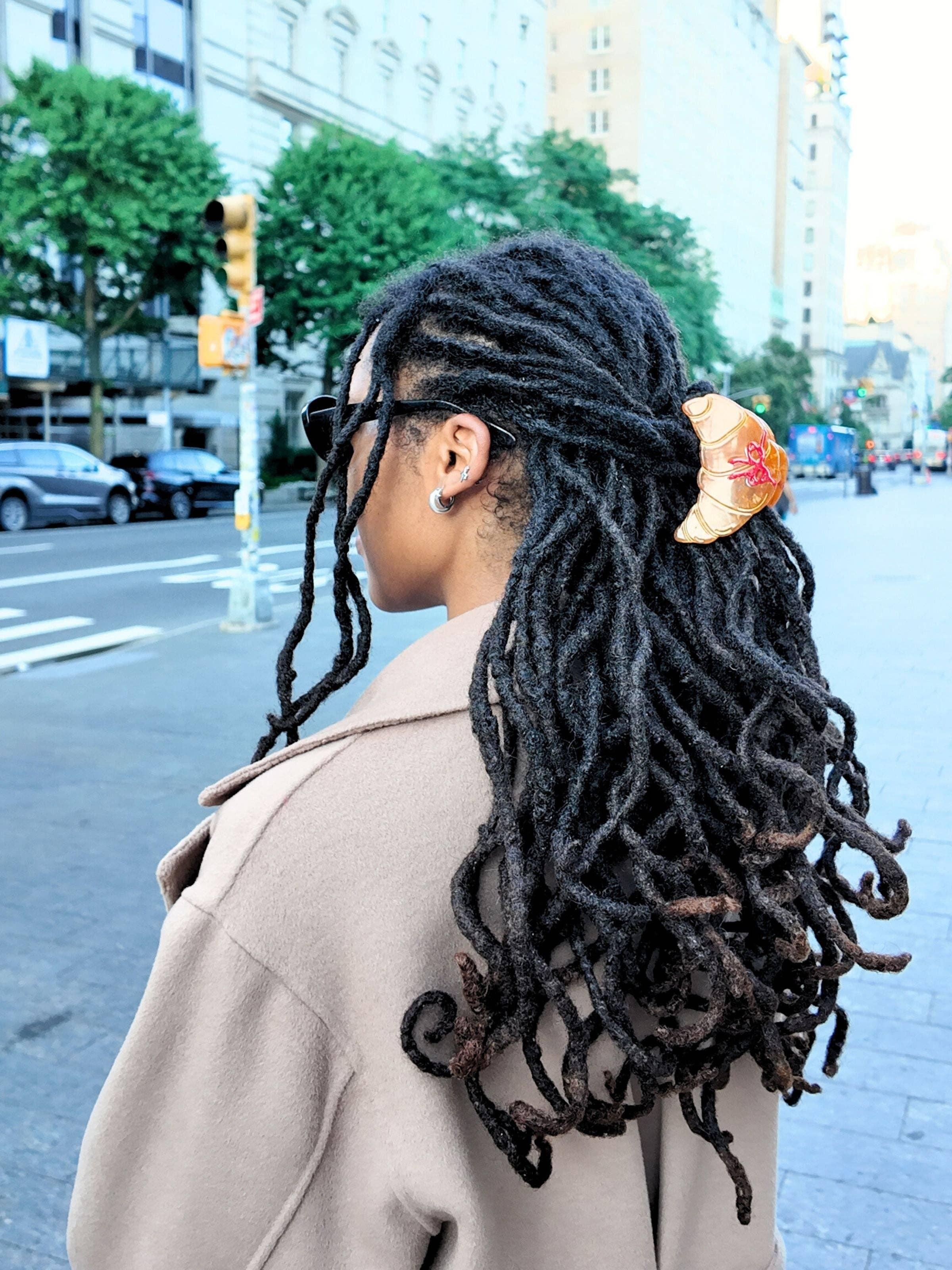 DEMIURGUS croissant hair clip in gold resin with red detail on dark locs, urban street style