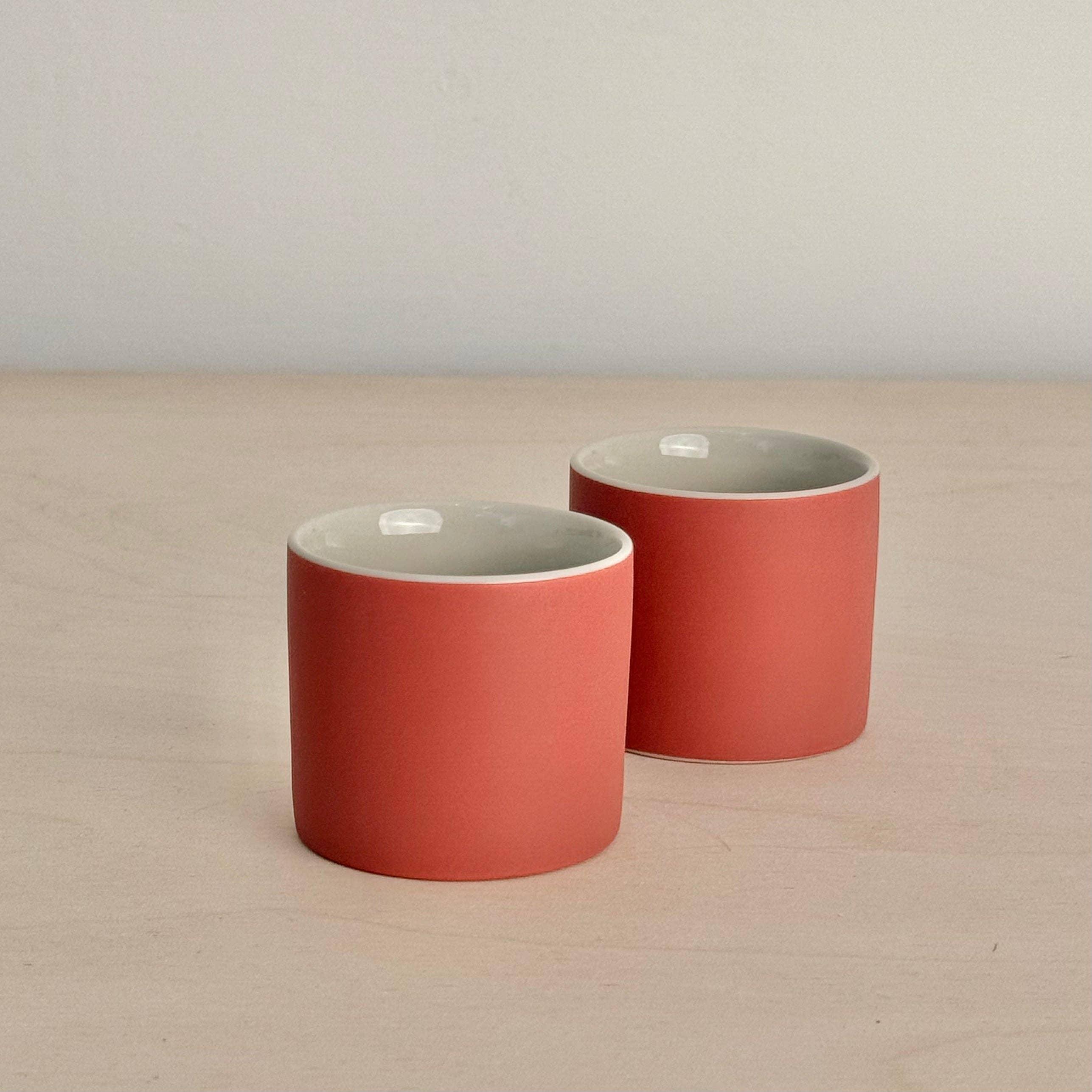 SIN Ceramics pink porcelain cups with matte finish on a light wood surface