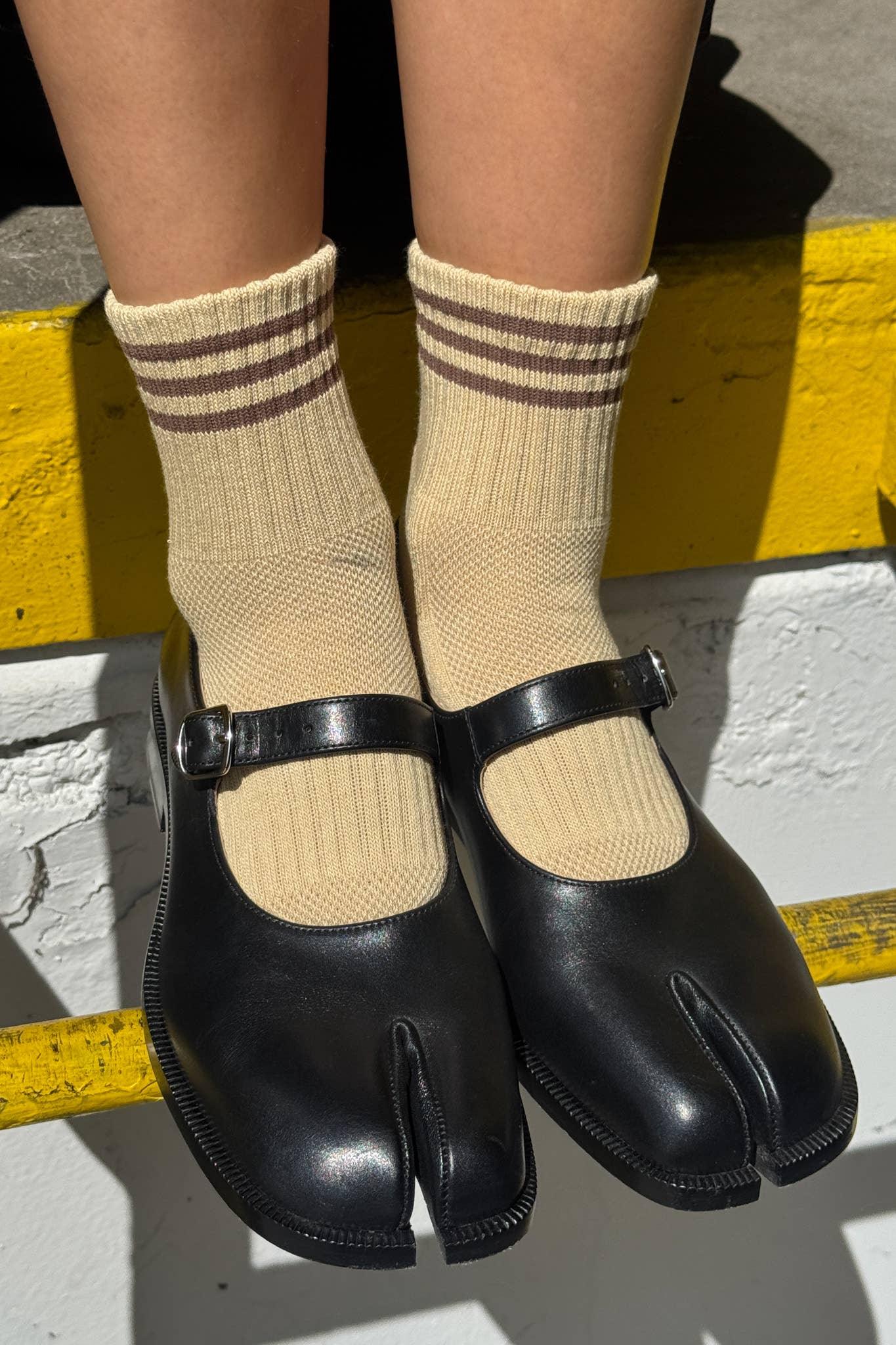 Maison Margiela black leather Tabi Mary Jane shoes with cream socks, outdoor setting
