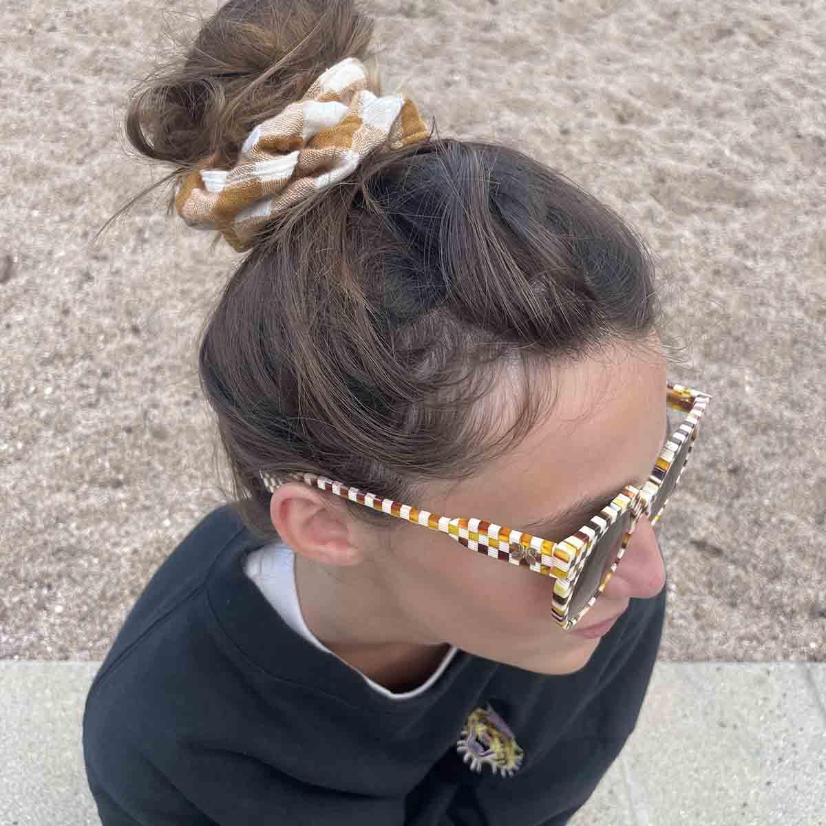 Chunks checkered acetate sunglasses in brown and white, worn with fabric scrunchie hair tie