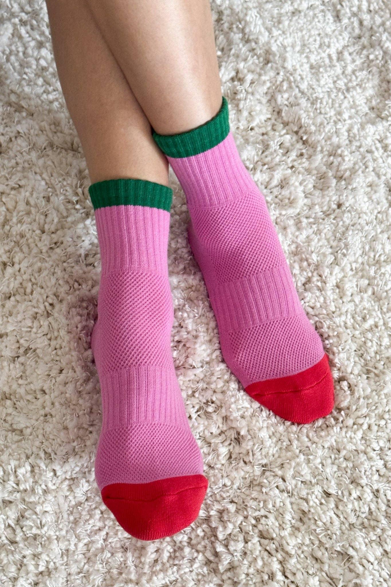 Coucou Suzette cotton socks, pink with green cuffs and red toes, on soft carpet